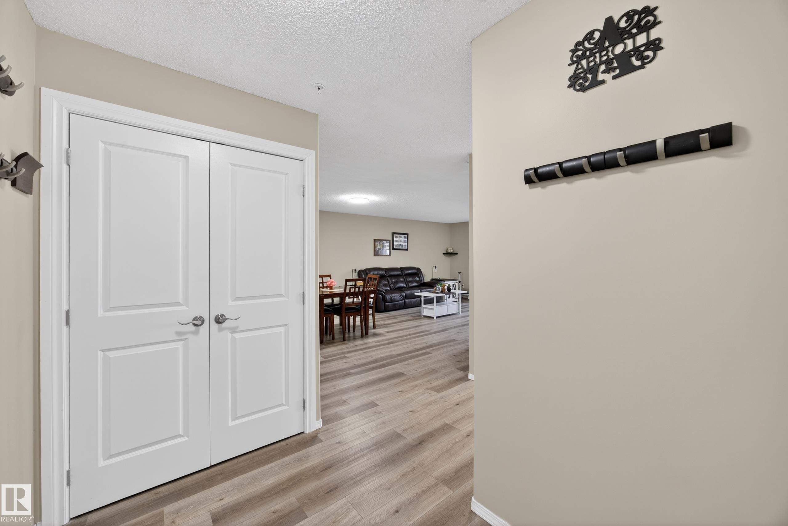 Hallway with light beige walls and wood-finish flooring - 138 16035 132 Street, Edmonton, AB