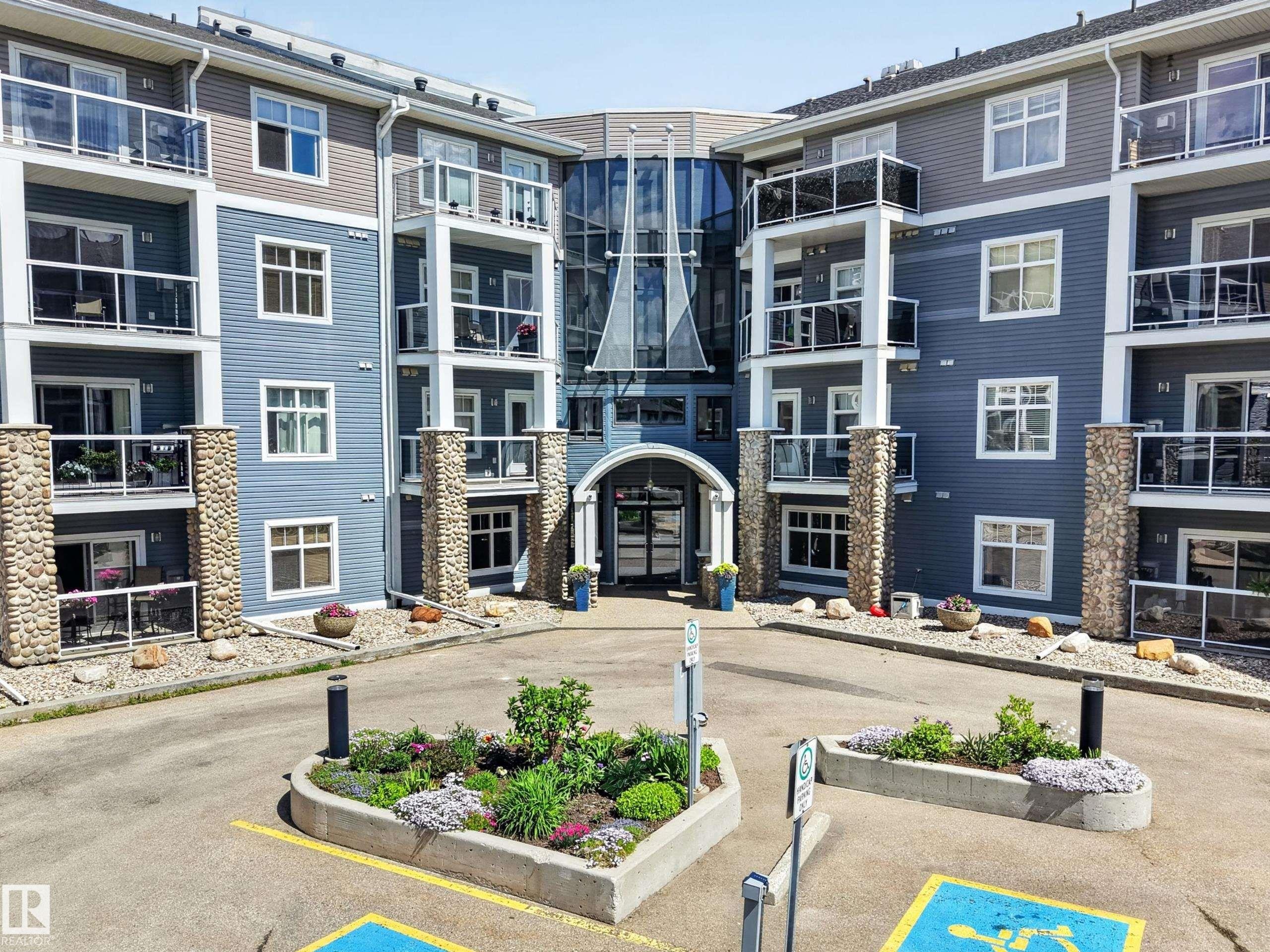 Modern multi-story building featuring a prominent glass-enclosed entrance - 138 16035 132 Street, Edmonton, AB