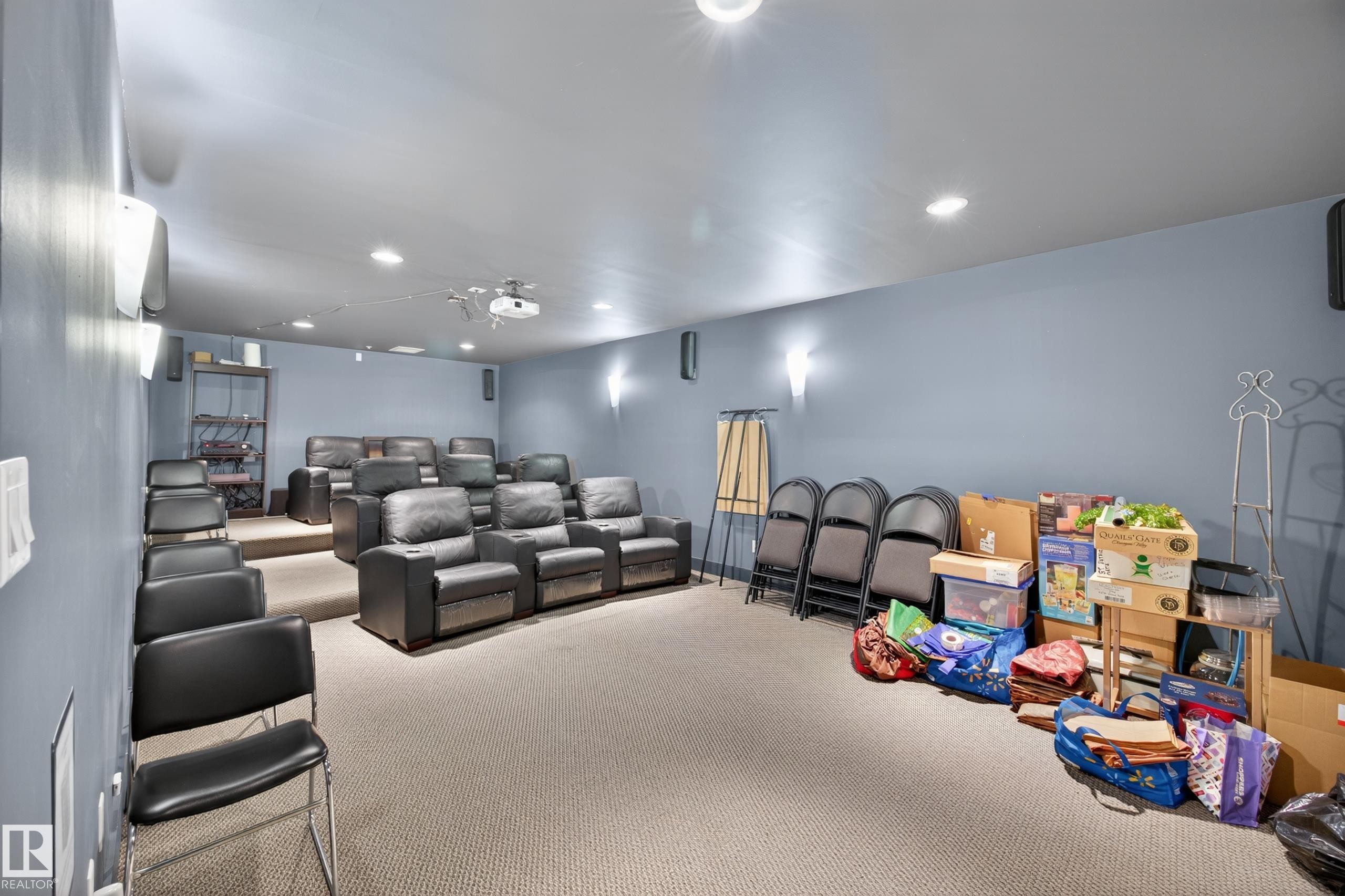 Dedicated media room featuring tiered seating, recessed lighting, and wall-mounted sconces - 138 16035 132 Street, Edmonton, AB