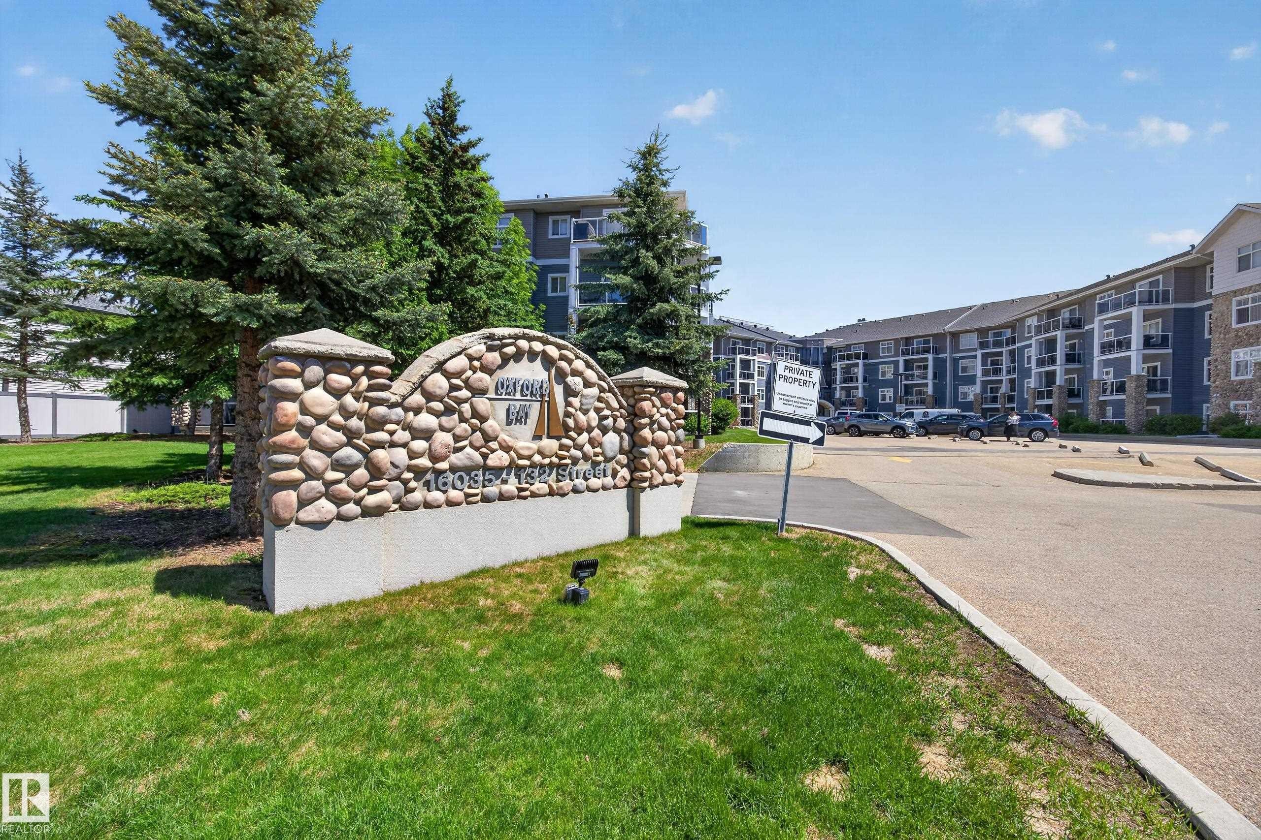Stone-clad monument signage with integrated landscaping and surrounding green space - 138 16035 132 Street, Edmonton, AB