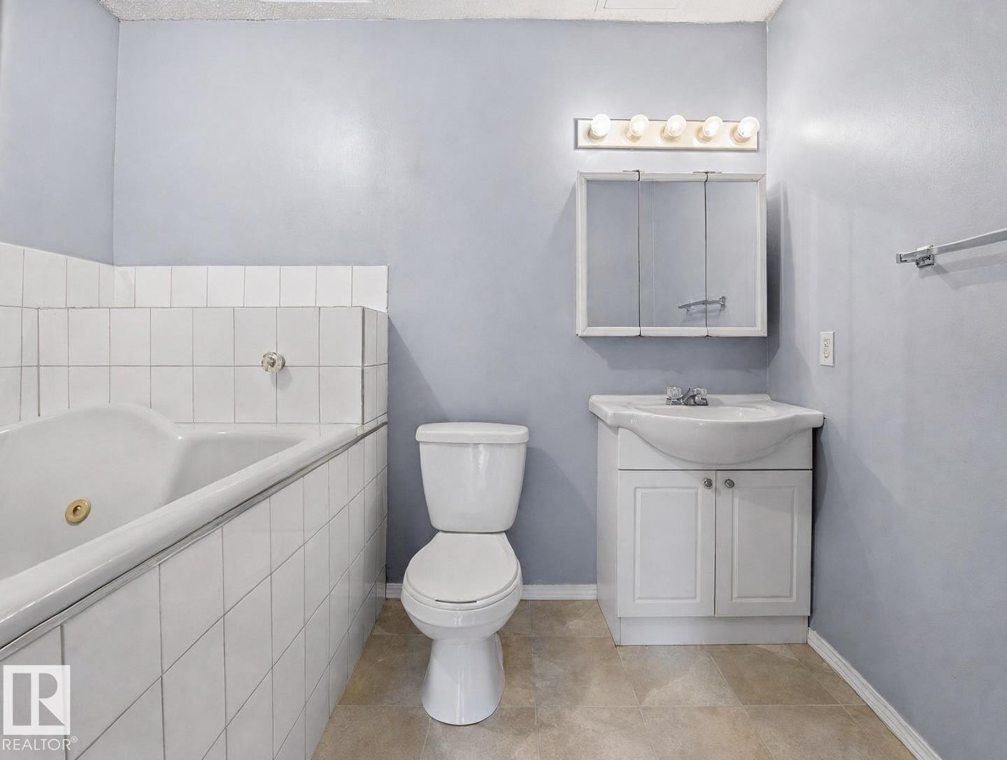 Full bathroom featuring a ceramic tile surround, pedestal sink with vanity storage, toilet, and ceramic tile flooring - #1 13450 Fort Rd Nw, Edmonton, AB - Indoor Photo Showing Bathroom