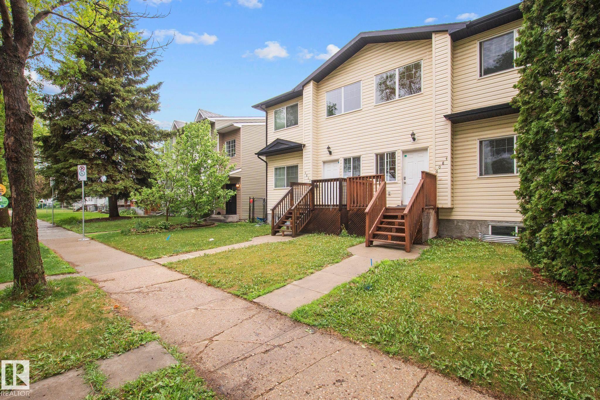 Townhome exterior with light-colored horizontal siding and dark trim - 4806 117 Ave, Edmonton, AB