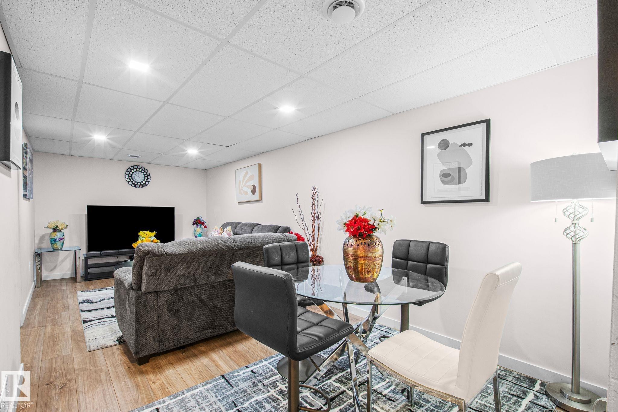 Recreation room featuring recessed lighting, light-toned walls, and wood-finish flooring - 4806 117 Ave, Edmonton, AB