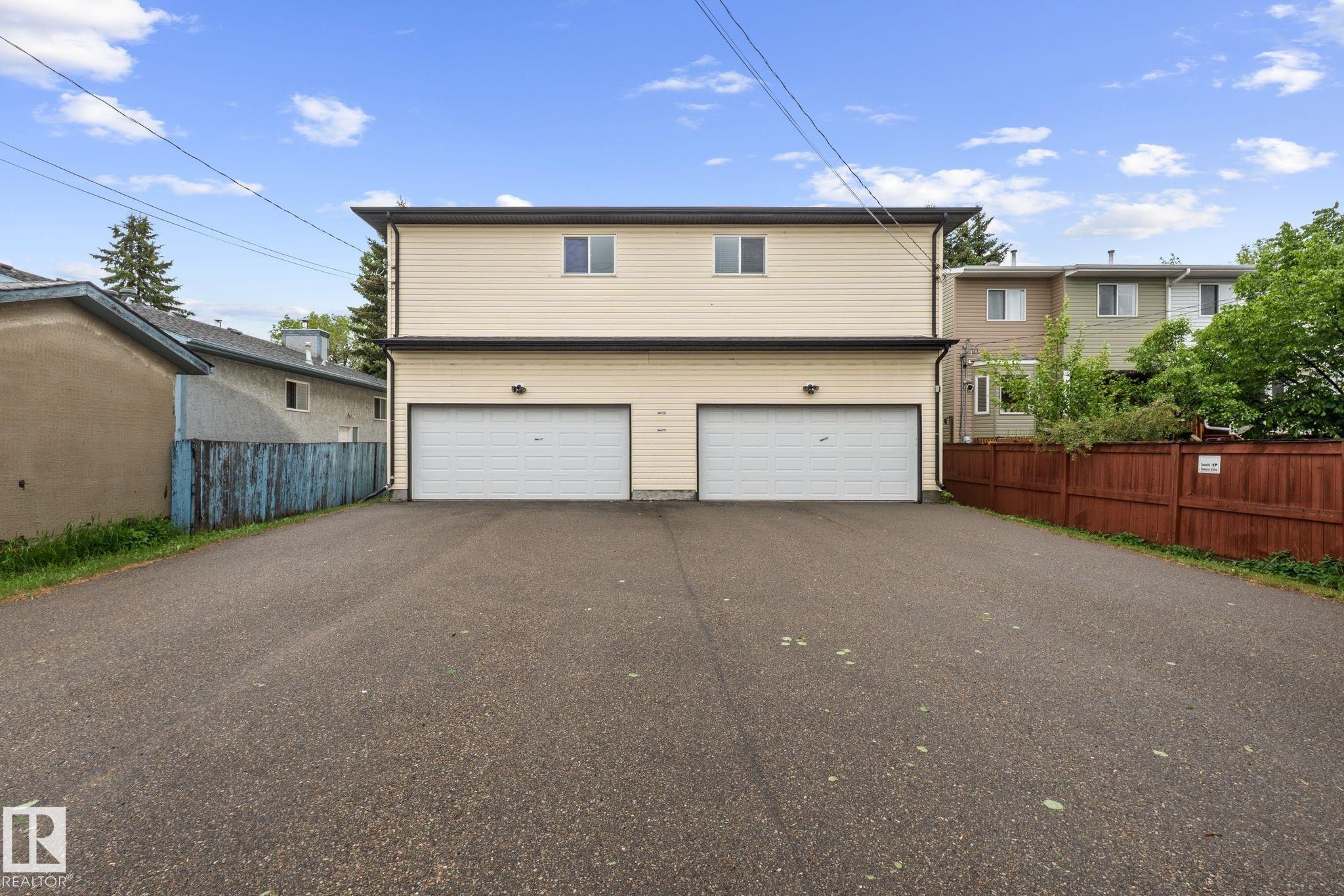 Two-story duplex with light-colored siding and a dark trim - 4806 117 Ave, Edmonton, AB