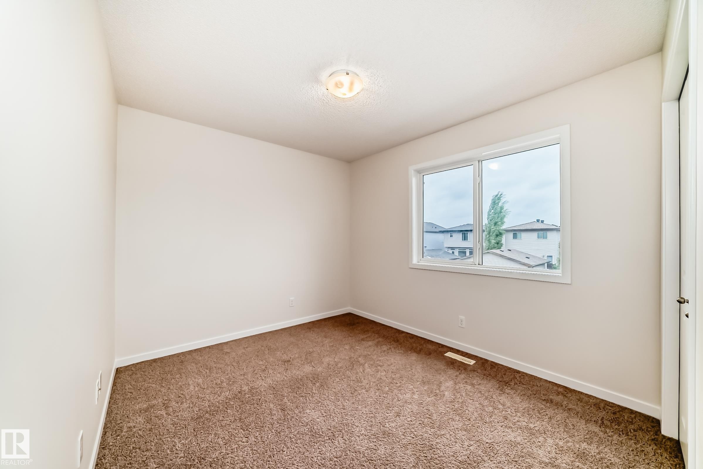 Neutral tone painted walls complement the brown carpeted flooring - 18103 77 Street, Edmonton, AB