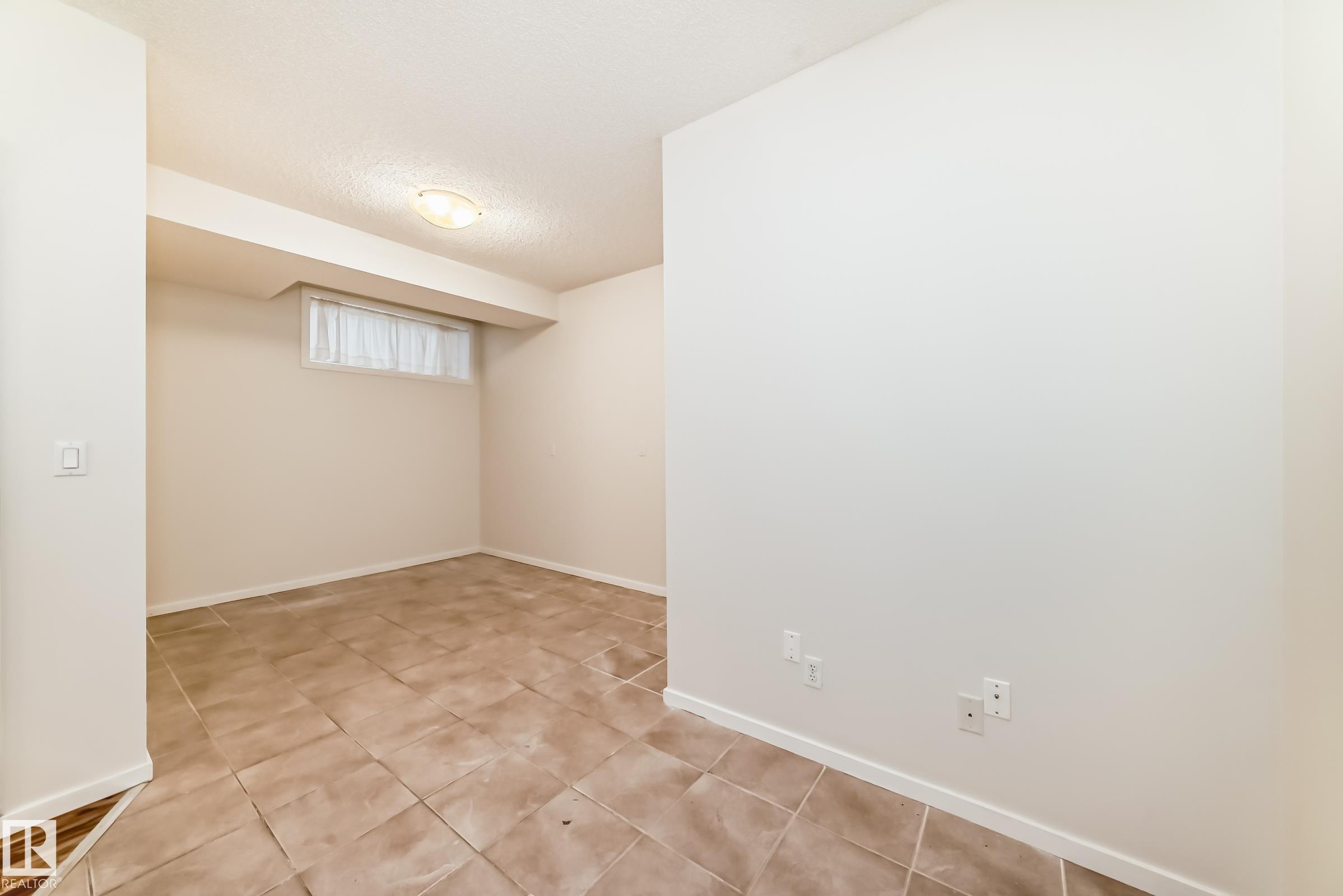 Room featuring light-colored walls and a neutral-toned tile floor - 18103 77 Street, Edmonton, AB