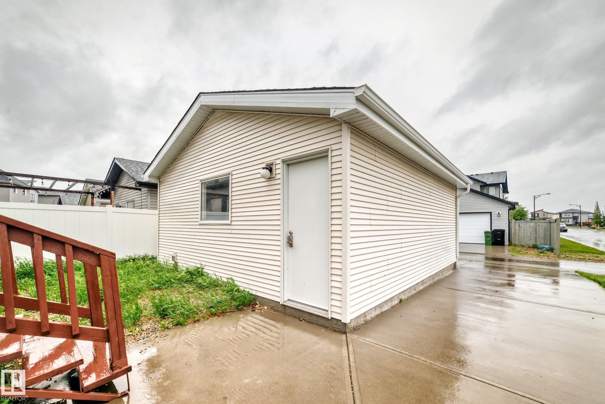 Detached garage featuring horizontal siding, a side entry door, and a single window - 18103 77 Street, Edmonton, AB