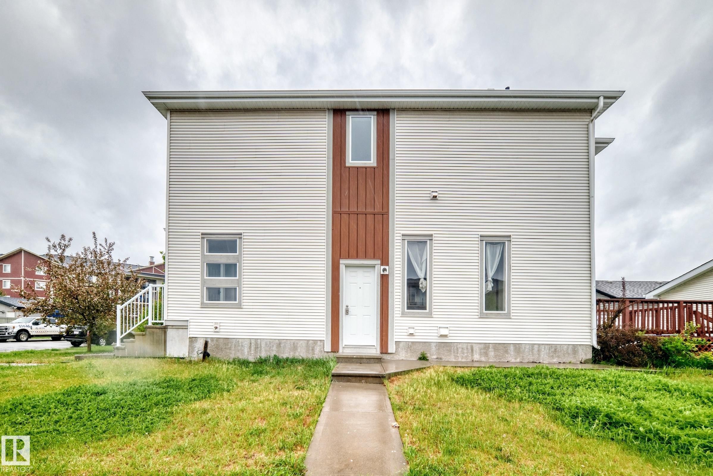 Modern two-story facade featuring white horizontal siding and brown vertical paneling - 18103 77 Street, Edmonton, AB
