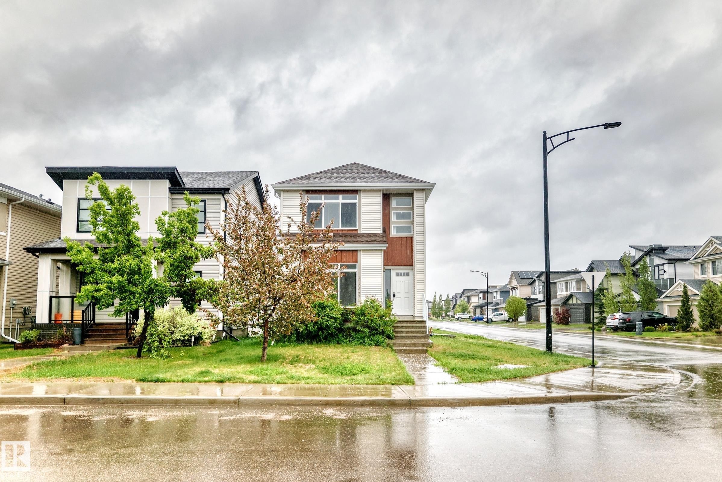 Contemporary two-story residence featuring a white and warm wood-tone exterior - 18103 77 Street, Edmonton, AB