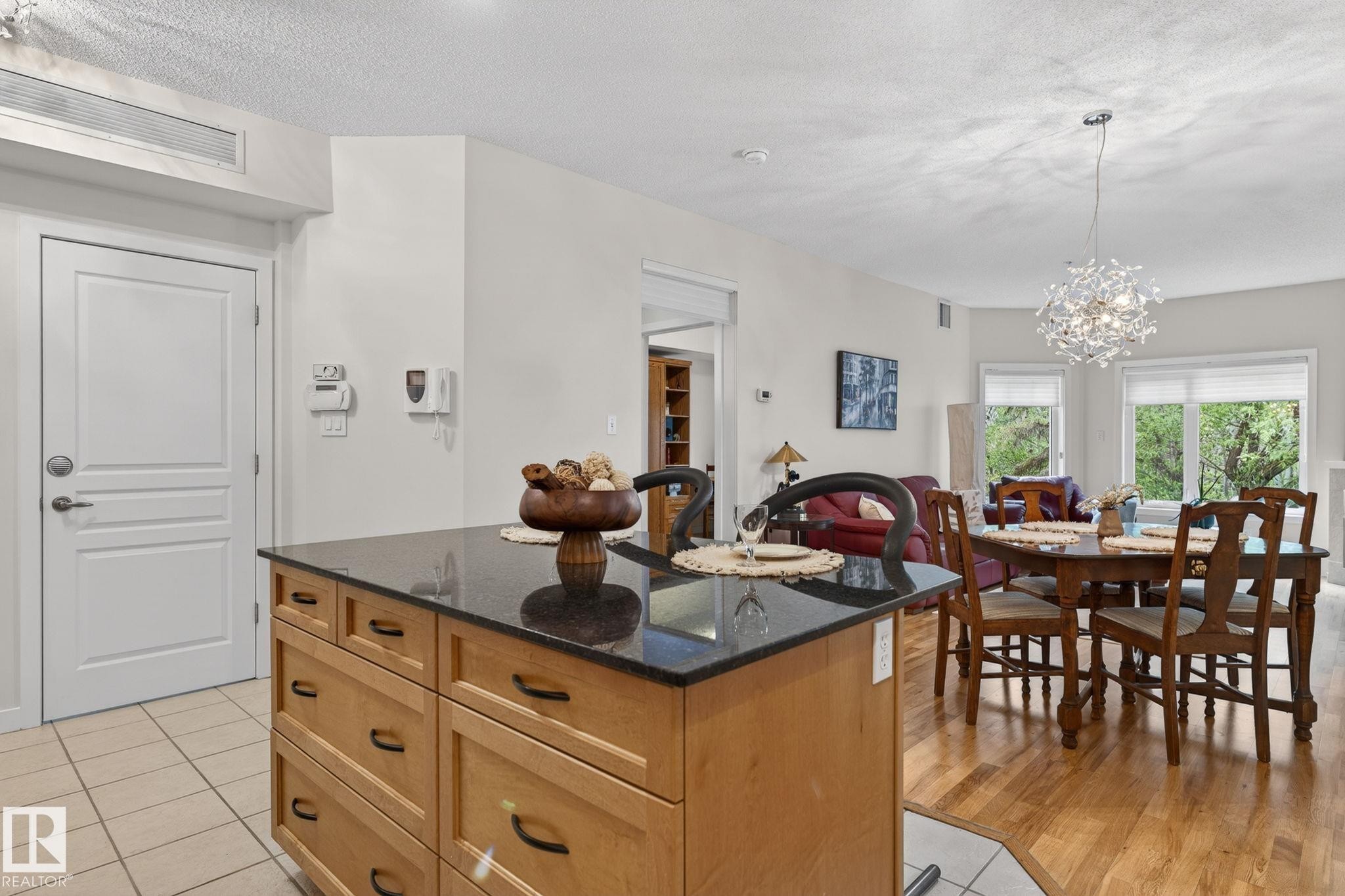 Kitchen island featuring a dark countertop and light wood-finish cabinetry - 208 5 Gate Avenue, St. Albert, AB