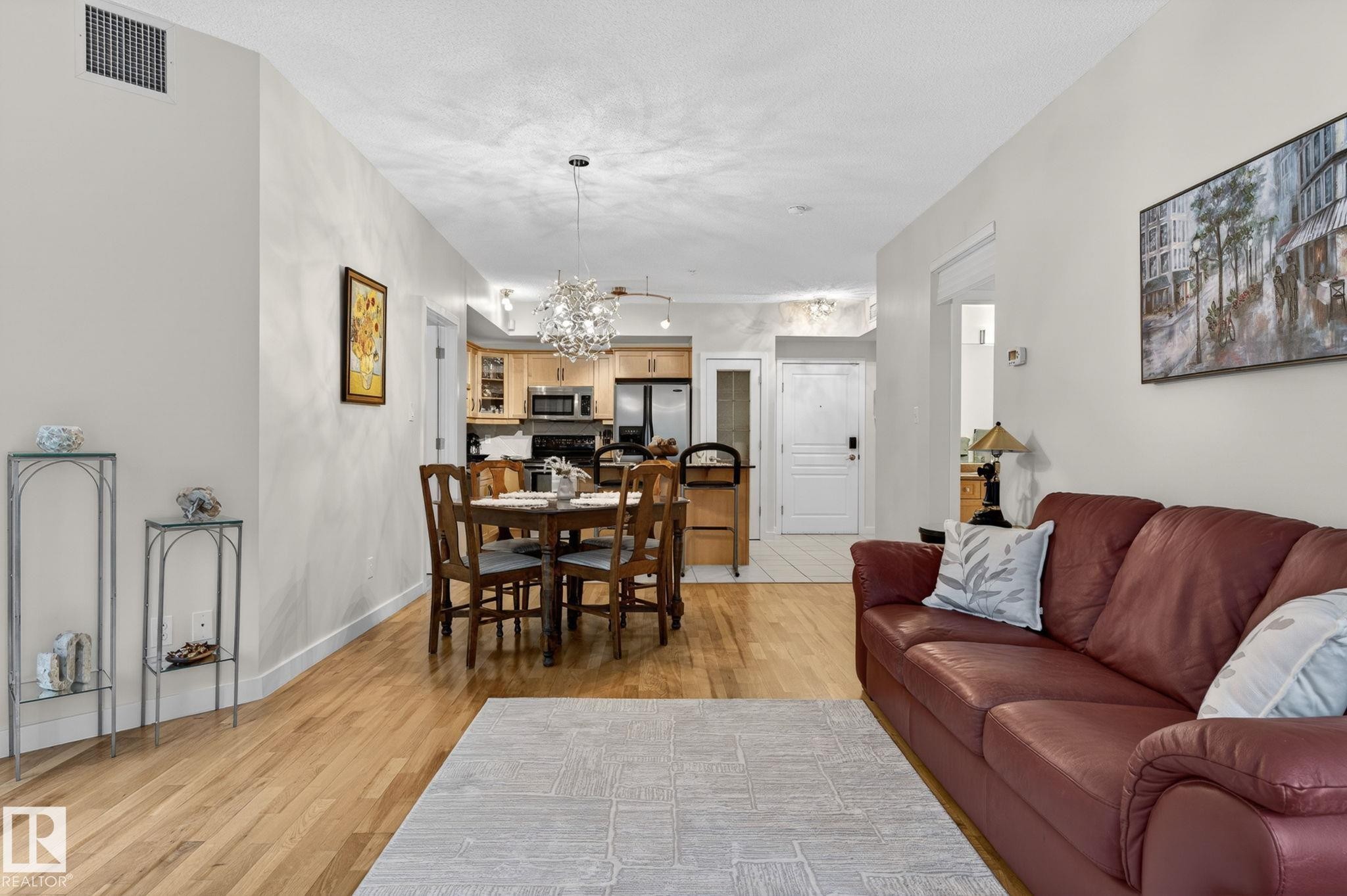 Open-concept living area featuring wood-finish flooring and neutral wall tones - 208 5 Gate Avenue, St. Albert, AB