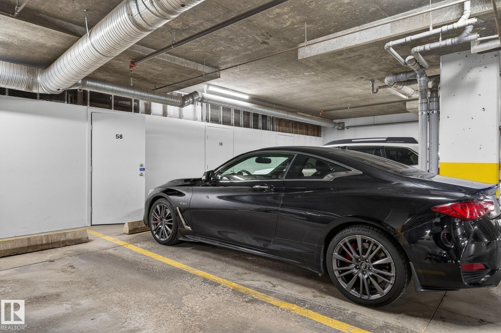Concrete parking area featuring overhead exposed ductwork and utility piping - 208 5 Gate Avenue, St. Albert, AB
