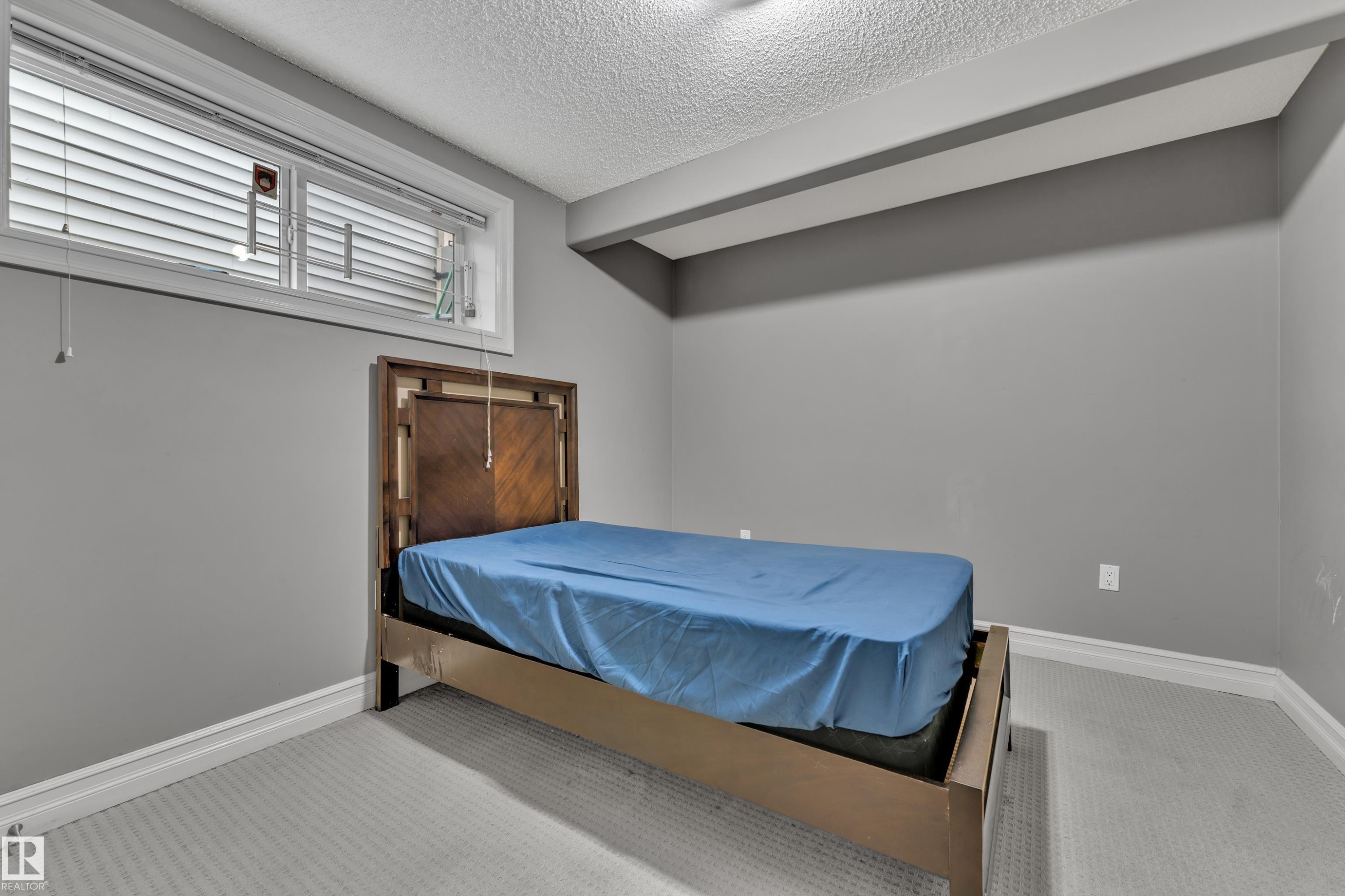 Carpeted room with a horizontal window featuring blinds - 6116 11 Avenue, Edmonton, AB