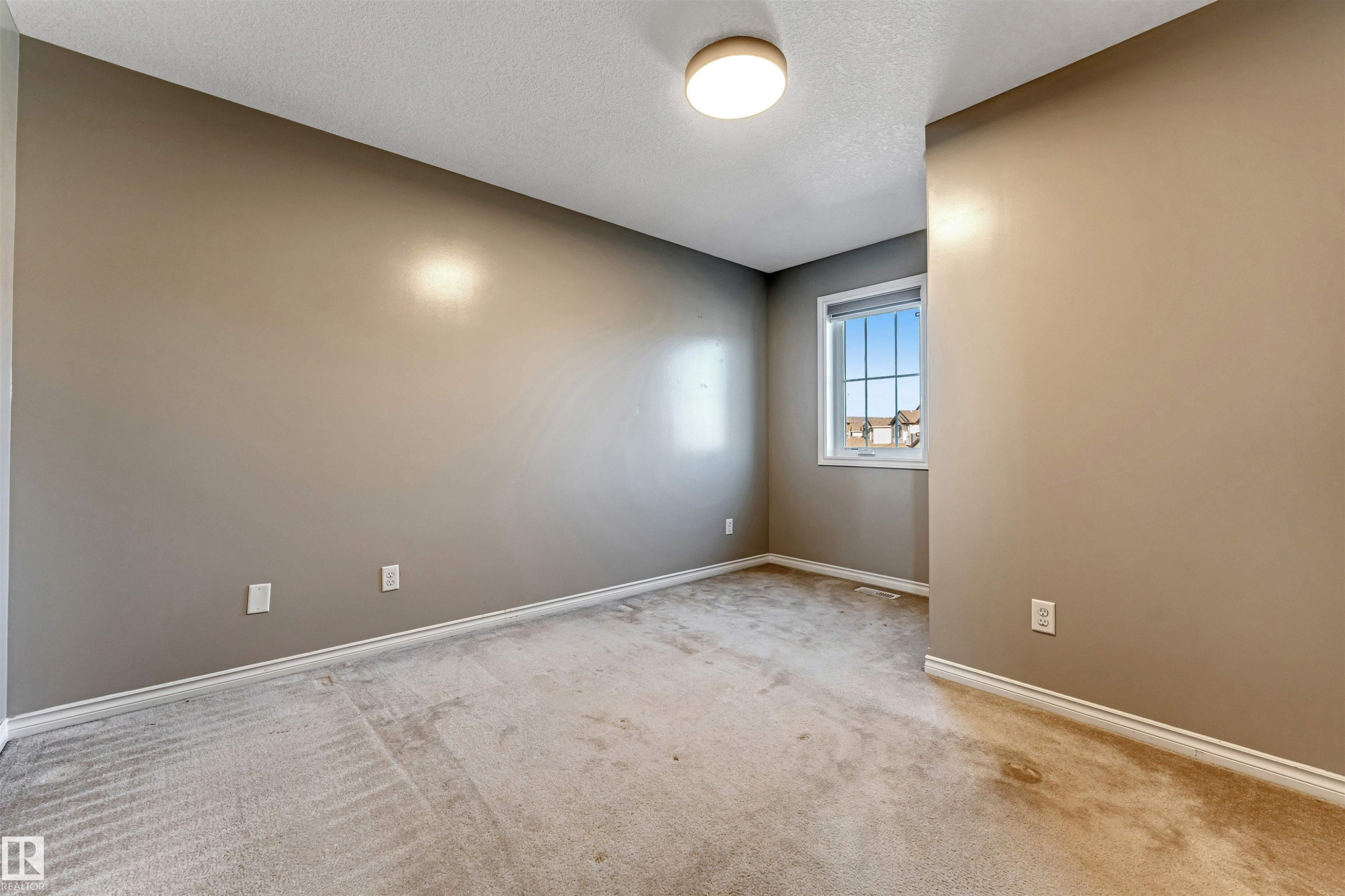 Neutral-toned walls complement plush carpet flooring - 5928 12 Avenue, Edmonton, AB