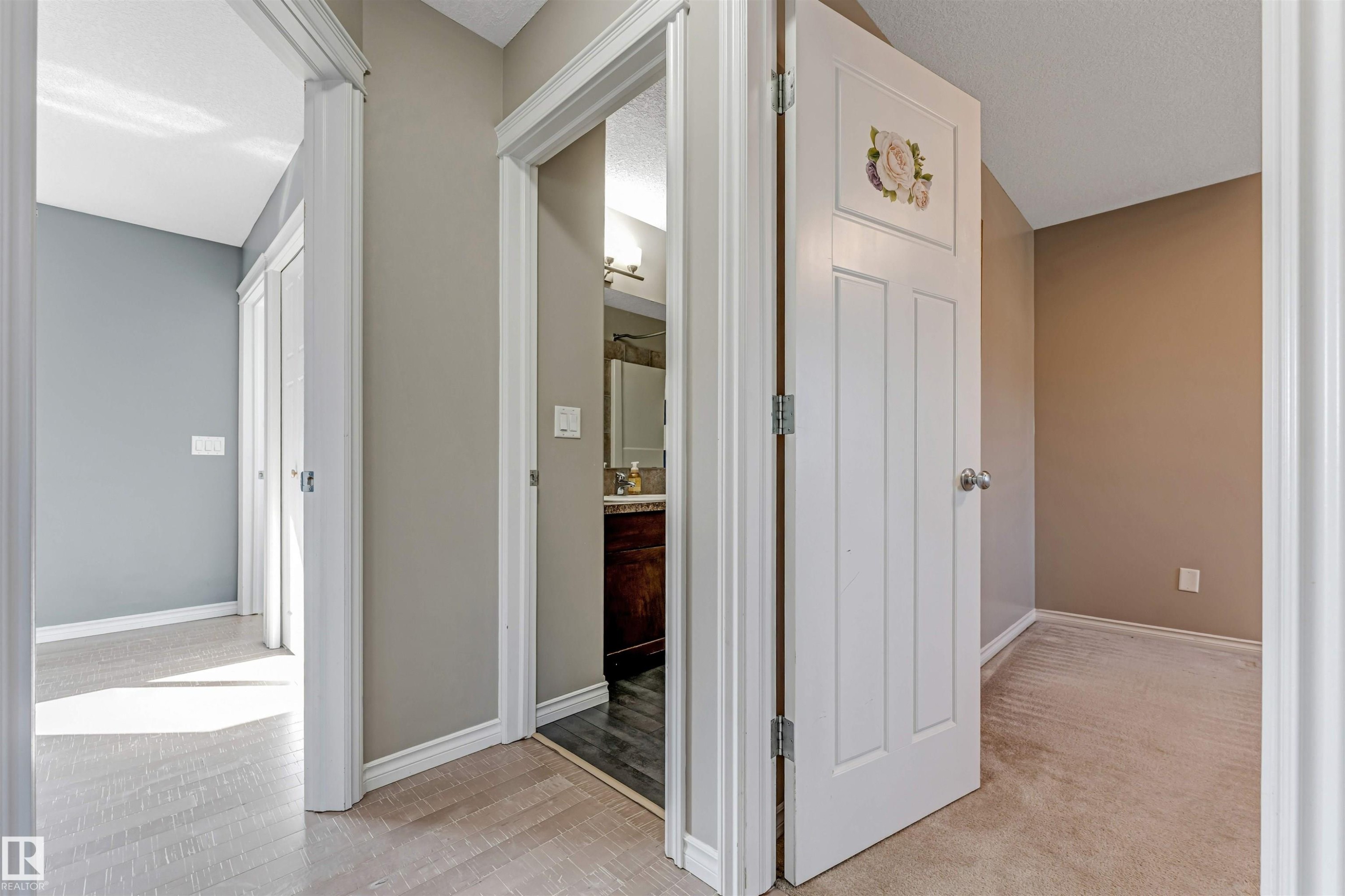 Hallway with light wood-finish flooring, white baseboards, and neutral wall paint - 5928 12 Avenue, Edmonton, AB