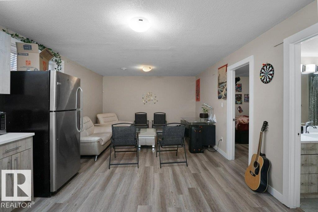 Open concept living area featuring wood-finish flooring, light-toned walls, and recessed lighting - 3756 8 Street, Edmonton, AB