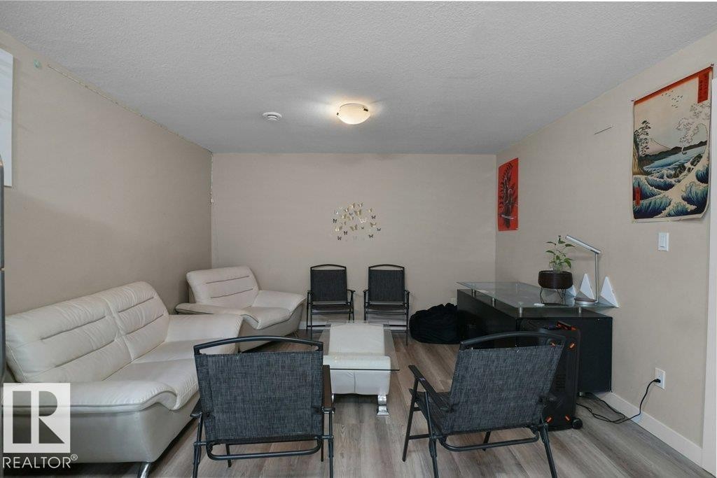 Spacious room featuring light-toned walls and wood-finish flooring - 3756 8 Street, Edmonton, AB