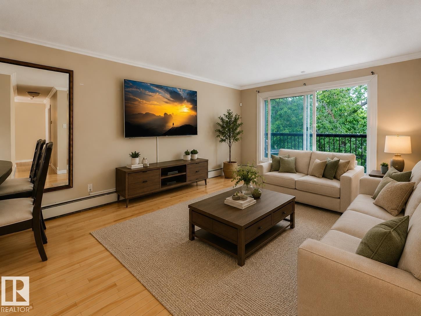 Living room featuring light wood-finish flooring, a neutral wall color, and white crown molding - #403 10165 113 St Nw, Edmonton, AB