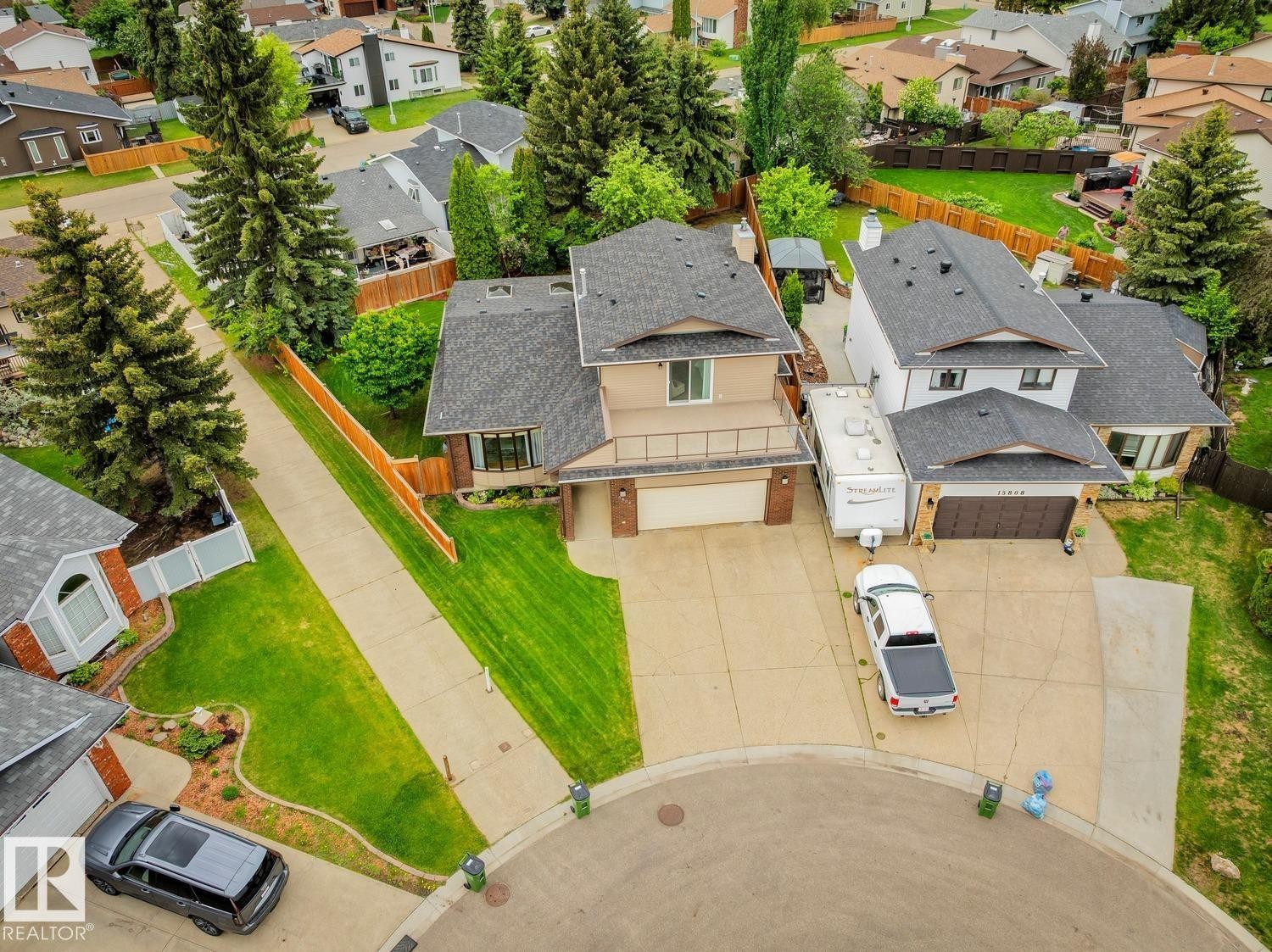 Cul-de-sac property featuring a tan facade with brick accents and a double-car garage - 15804 80 Street, Edmonton, AB