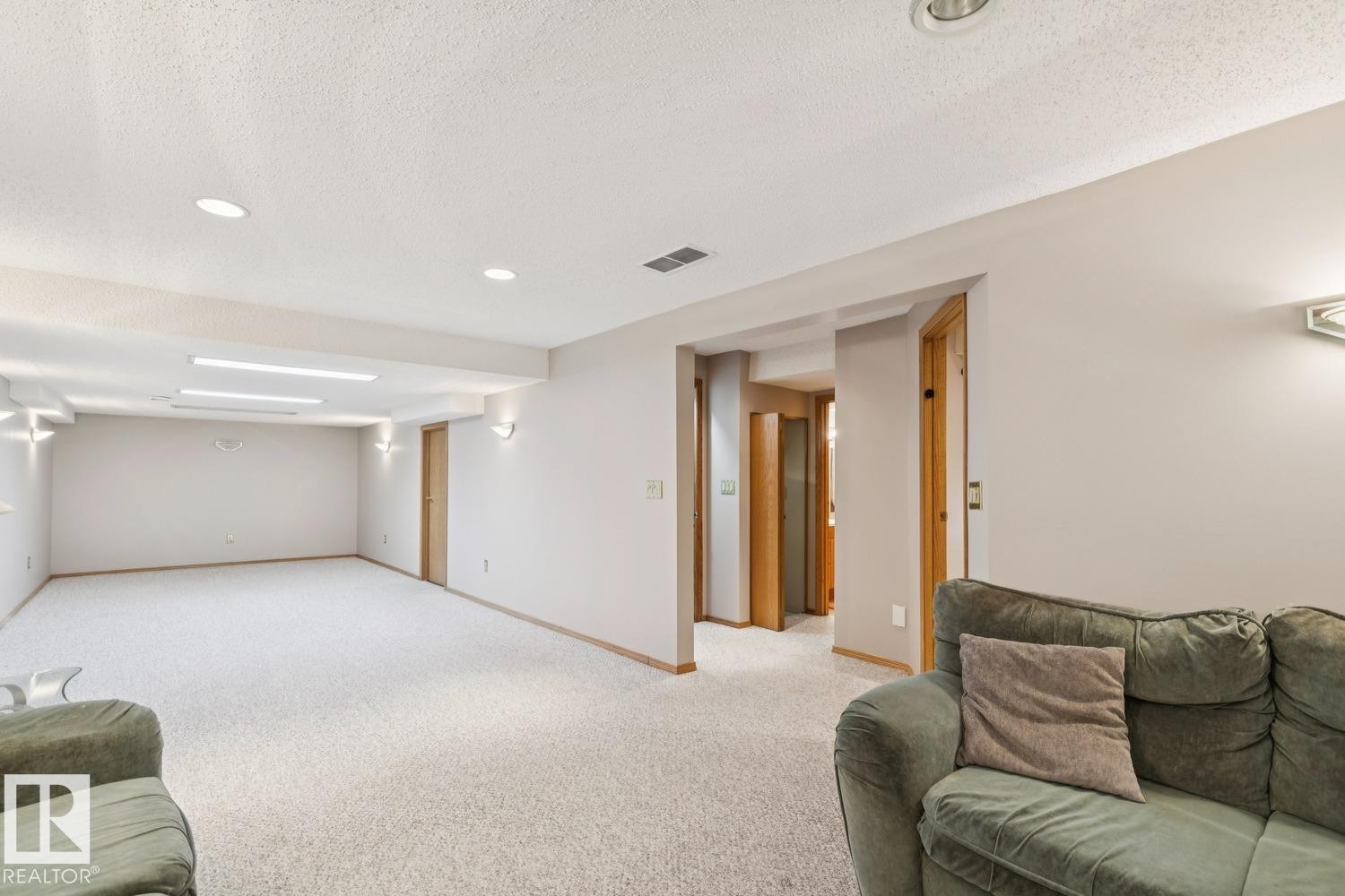 Spacious room featuring light-colored carpeting, recessed lighting, and neutral wall tones - 15804 80 Street, Edmonton, AB