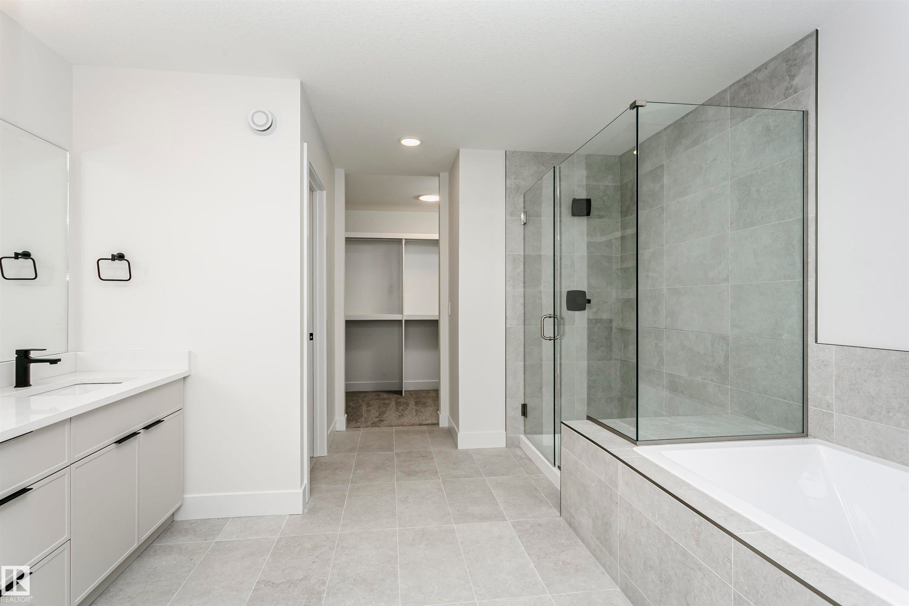 Contemporary bathroom featuring a spacious vanity with white countertop and matte black fixtures - 6210 Dansereau Crescent, Beaumont, AB