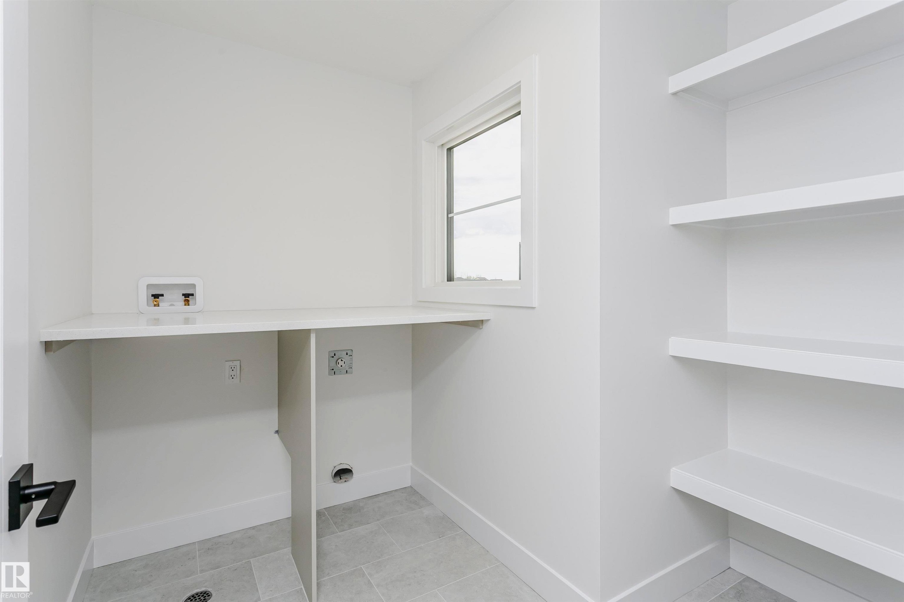 Dedicated laundry area featuring a white countertop, plumbing hookups, and a window for natural light - 6210 Dansereau Crescent, Beaumont, AB