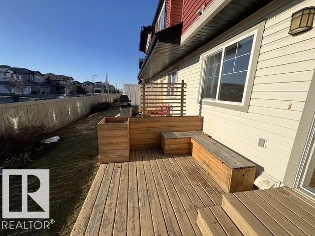 Expansive wood deck featuring built-in bench seating and a wood planter - #13 3751 12 Street, Edmonton, AB