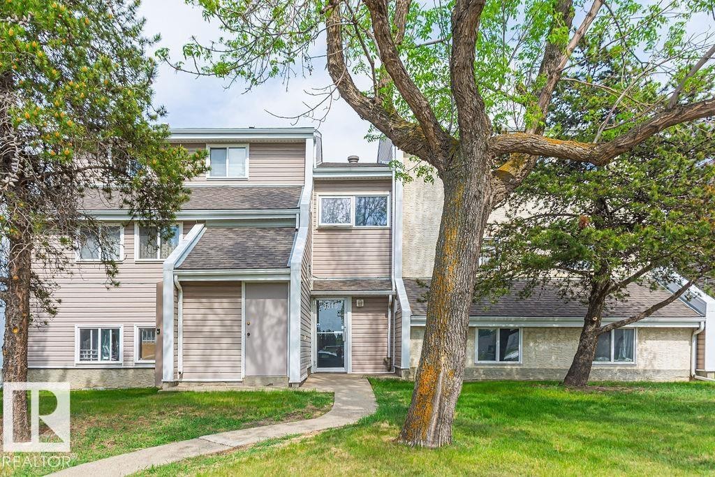 Exterior townhouse unit featuring light-colored siding and a dark shingle roof - 6 3819 76 Street, Edmonton, AB