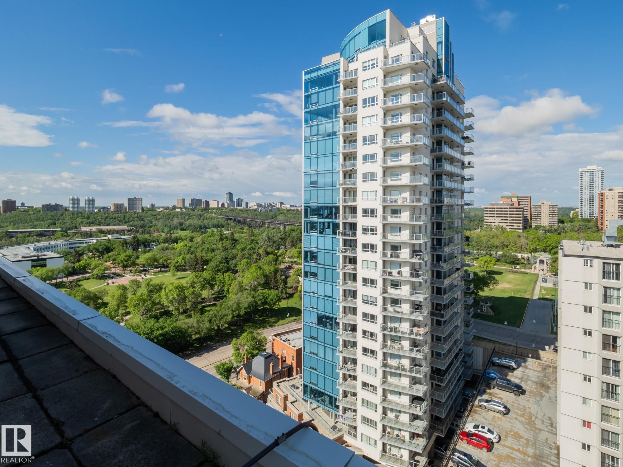 Contemporary high-rise building featuring a glass and white facade, multiple balconies, and a panoramic city backdrop - #Ph4 9725 106 St Nw, Edmonton, AB - Outdoor