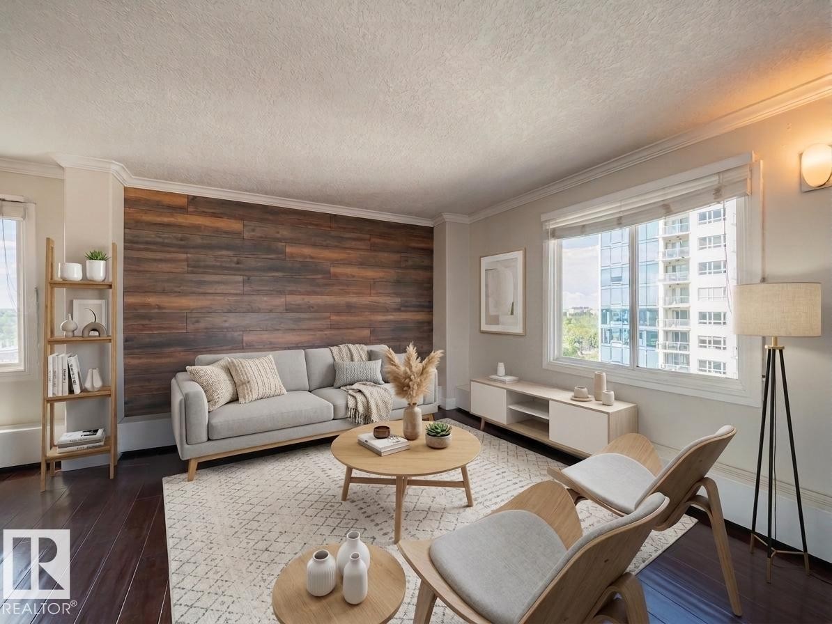 Living area featuring a prominent wood-panel accent wall, dark wood-finish flooring, and crown molding - #Ph4 9725 106 St Nw, Edmonton, AB - Indoor Photo Showing Living Room
