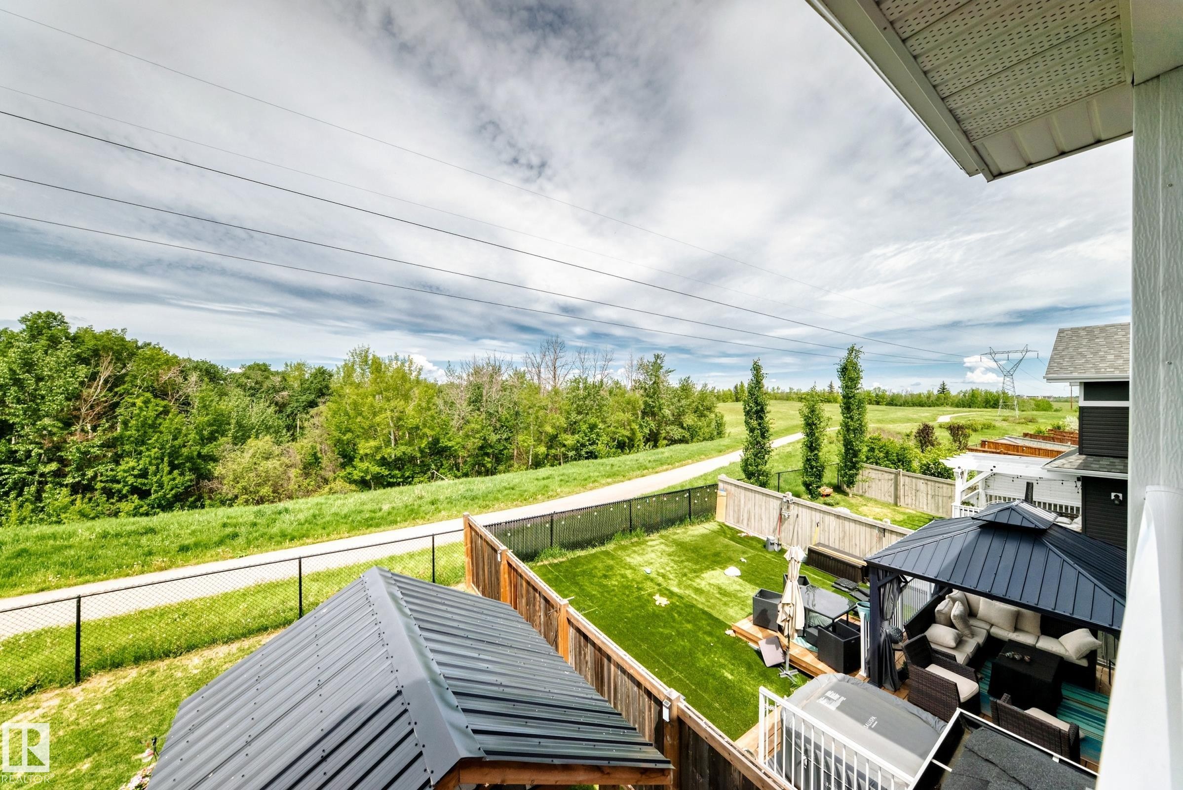 Expansive backyard featuring a lush lawn, privacy fencing, and a covered outdoor lounge area - 3895 Robins Crescent Nw, Edmonton, AB - Outdoor With Deck Patio Veranda