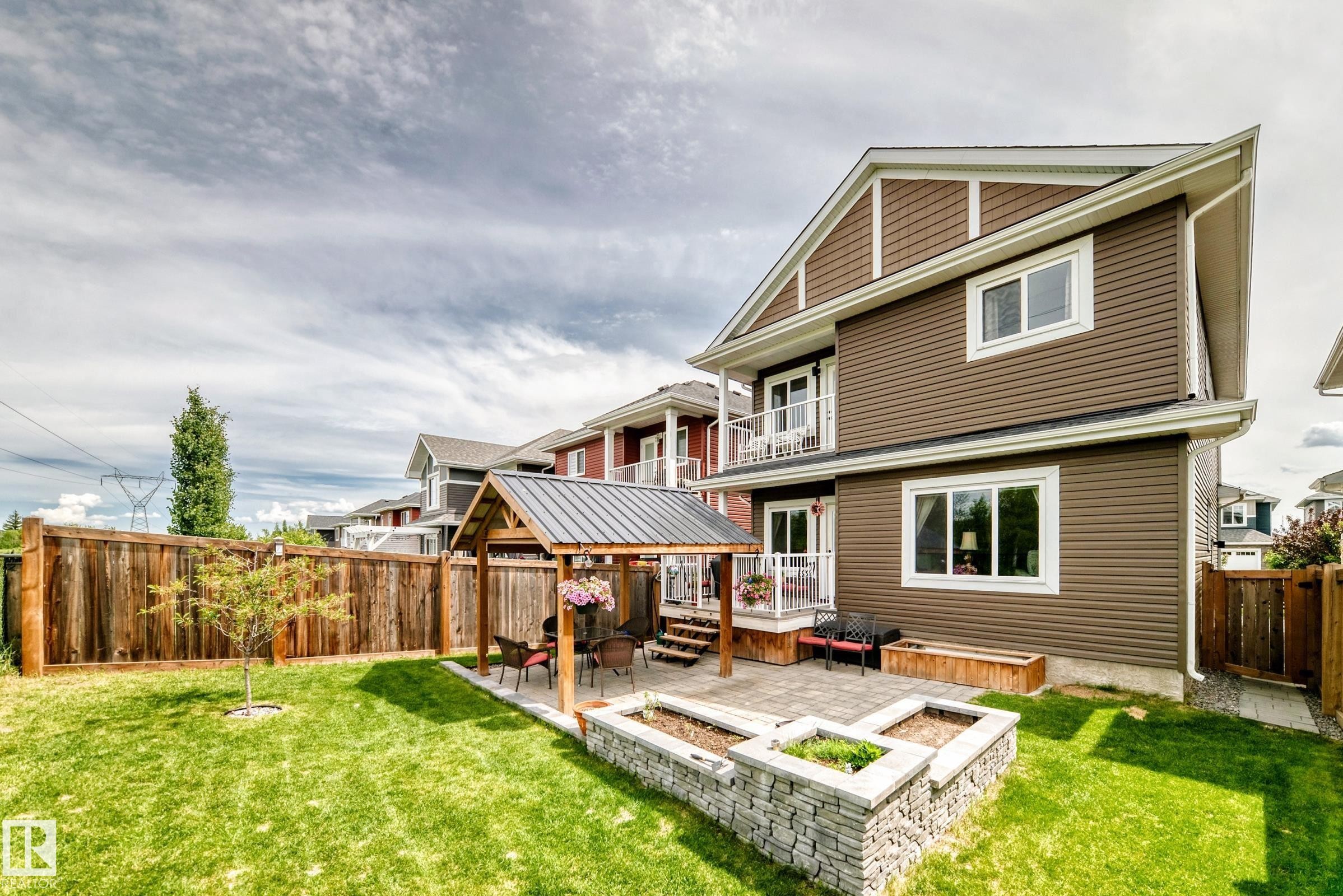 Spacious backyard featuring a manicured lawn, full privacy fencing, and a paved patio area - 3895 Robins Crescent Nw, Edmonton, AB - Outdoor