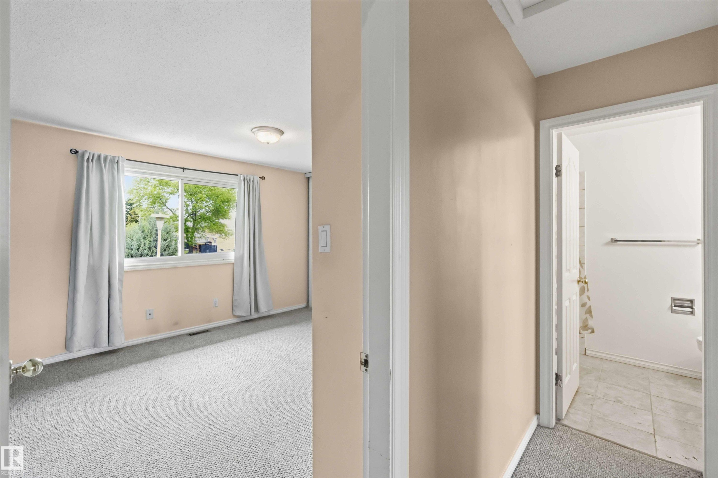 Carpeted interior room with a window, flush mount ceiling light, and light-toned walls - 17325 85 Avenue Nw, Edmonton, AB