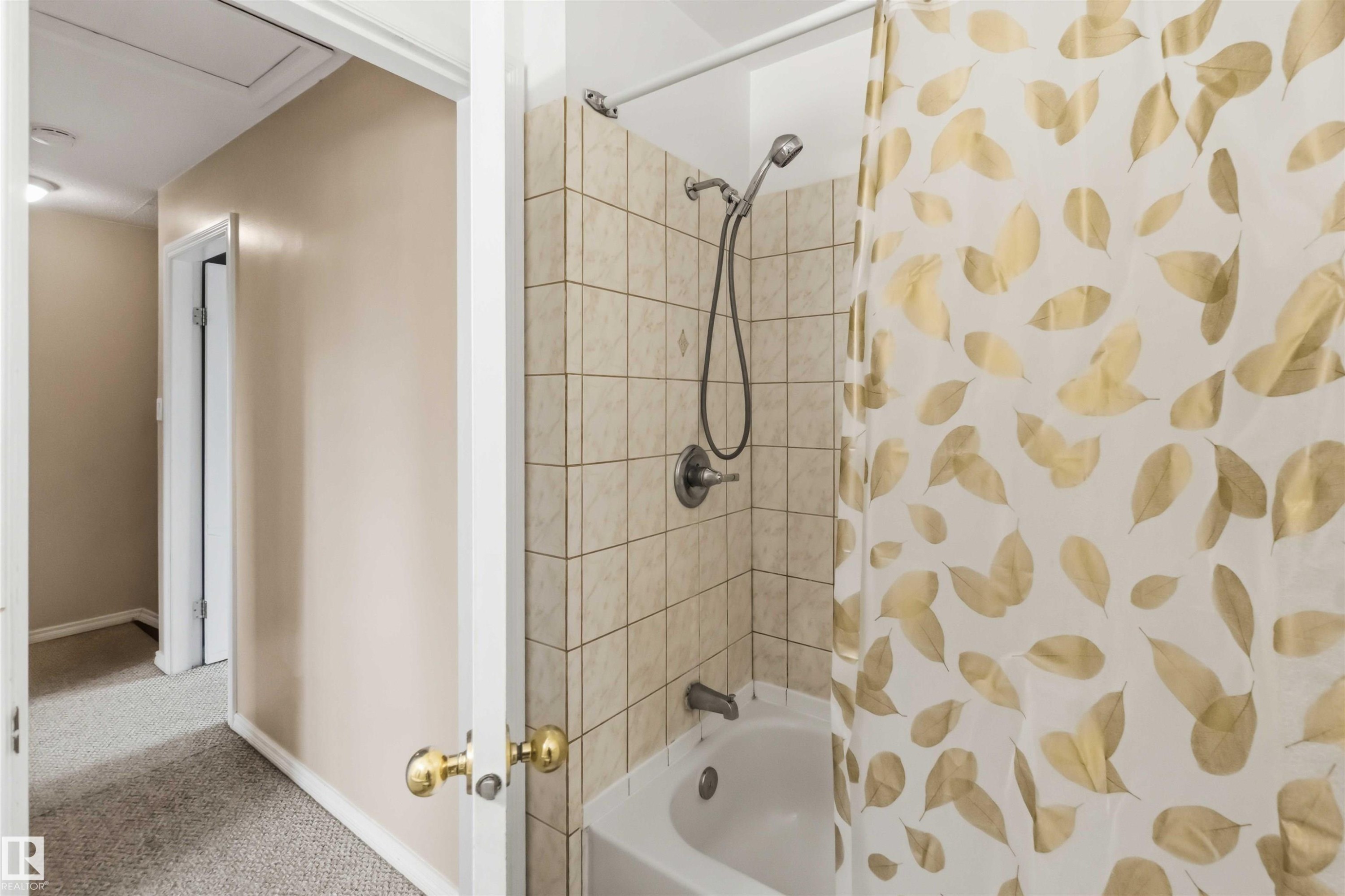 Bathroom featuring a white tub, light-toned square tile surround, and a brushed nickel shower fixture - 17325 85 Avenue Nw, Edmonton, AB