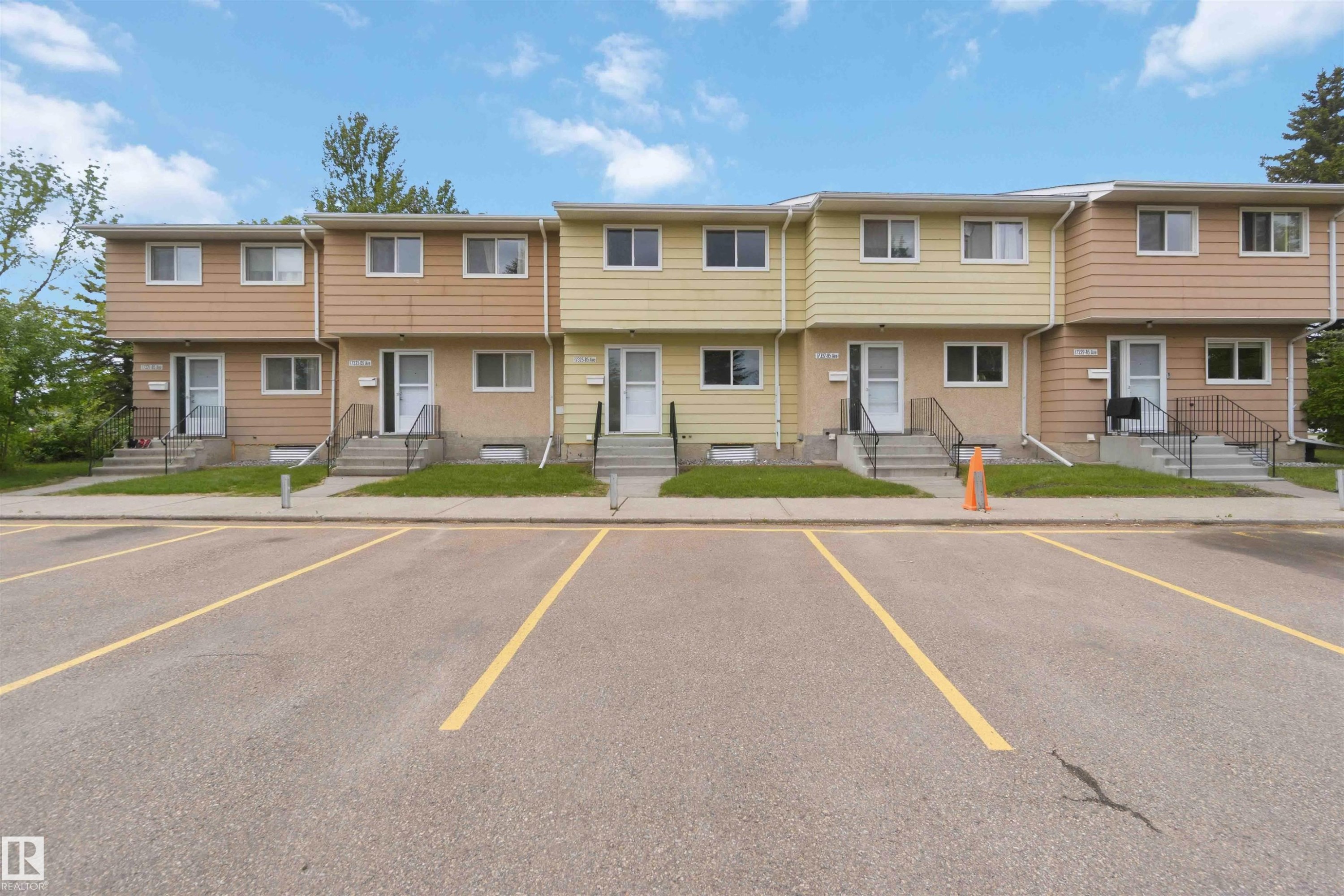 Townhouse exterior featuring two stories, multiple windows, and individual entrances - 17325 85 Avenue Nw, Edmonton, AB