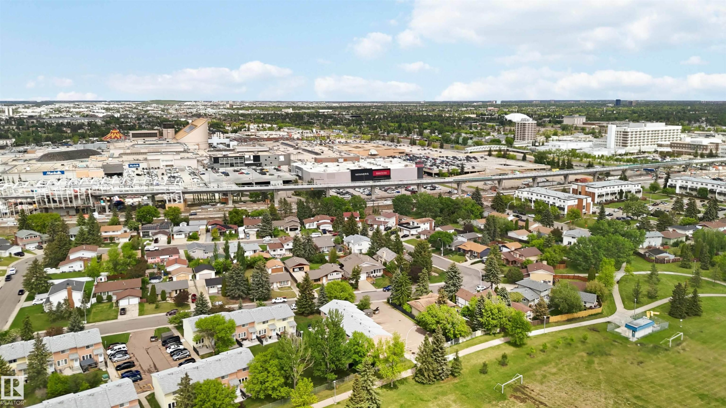 Aerial perspective showcasing a residential area with varied housing types, green spaces, and commercial developments - 17325 85 Avenue Nw, Edmonton, AB