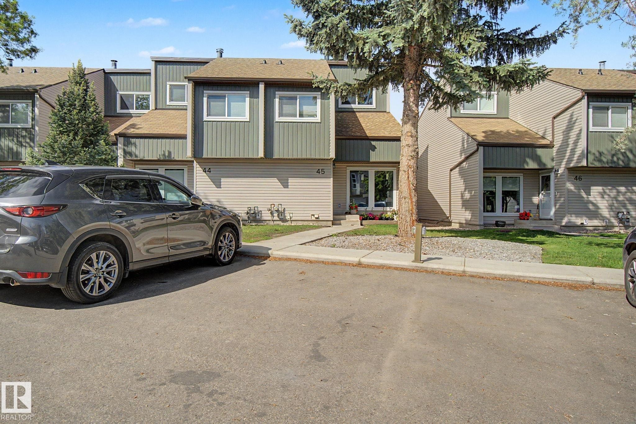 Townhome exterior featuring horizontal siding, vertical paneling, and a pitched roofline - #45 2020 105 St Nw, Edmonton, AB - Outdoor With Facade
