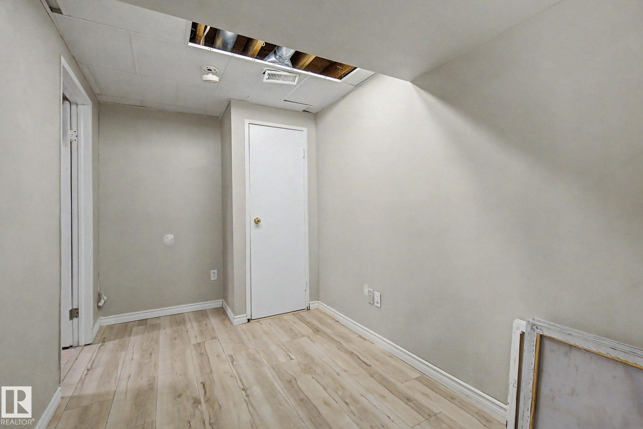 Room featuring wood-finish flooring, light gray painted walls, and white baseboards - #45 2020 105 St Nw, Edmonton, AB - Indoor Photo Showing Other Room