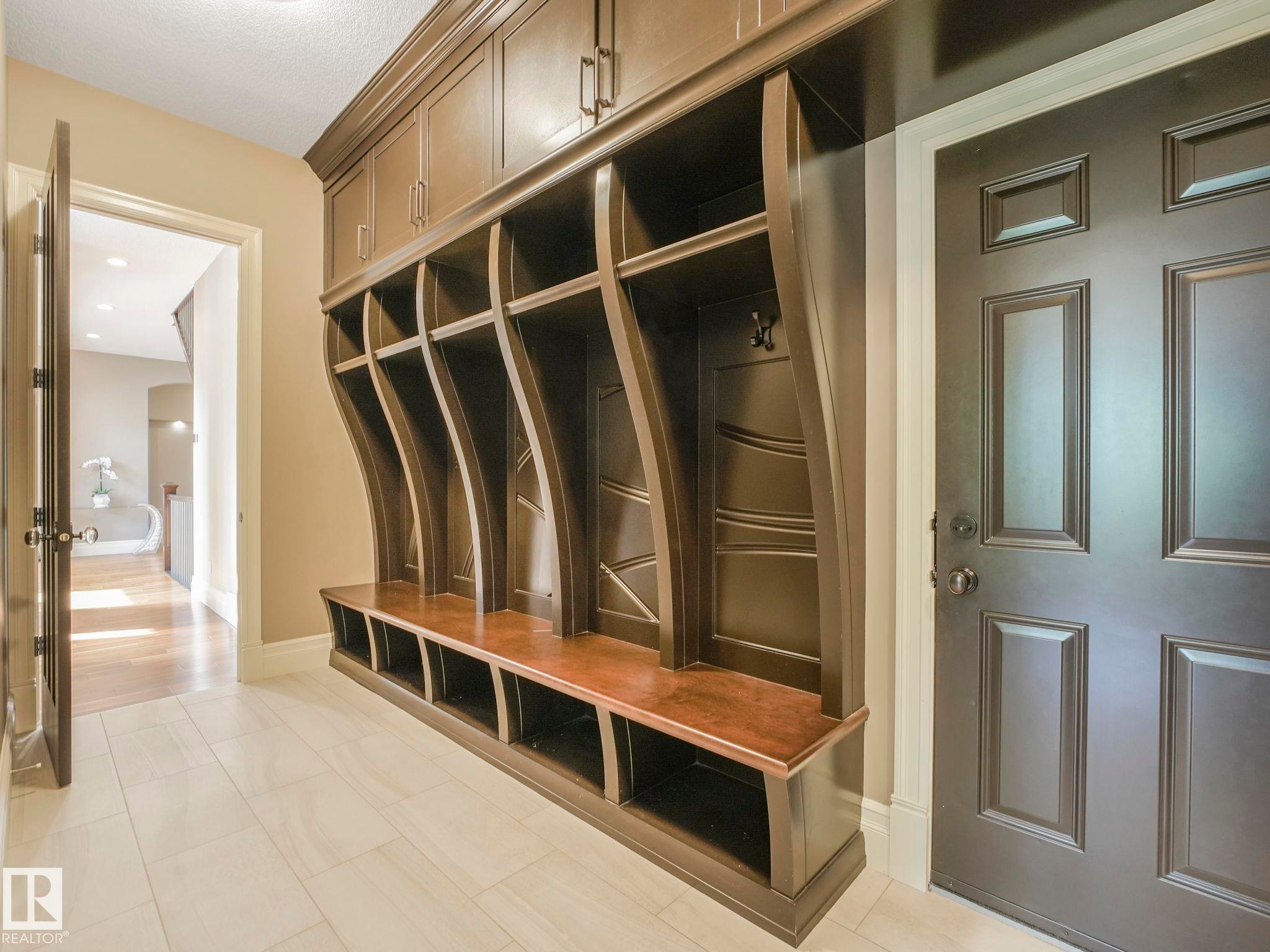 Custom built-in hall tree with upper cabinetry, open cubbies, and a seating bench - 2807 Wheaton Drive, Edmonton, AB