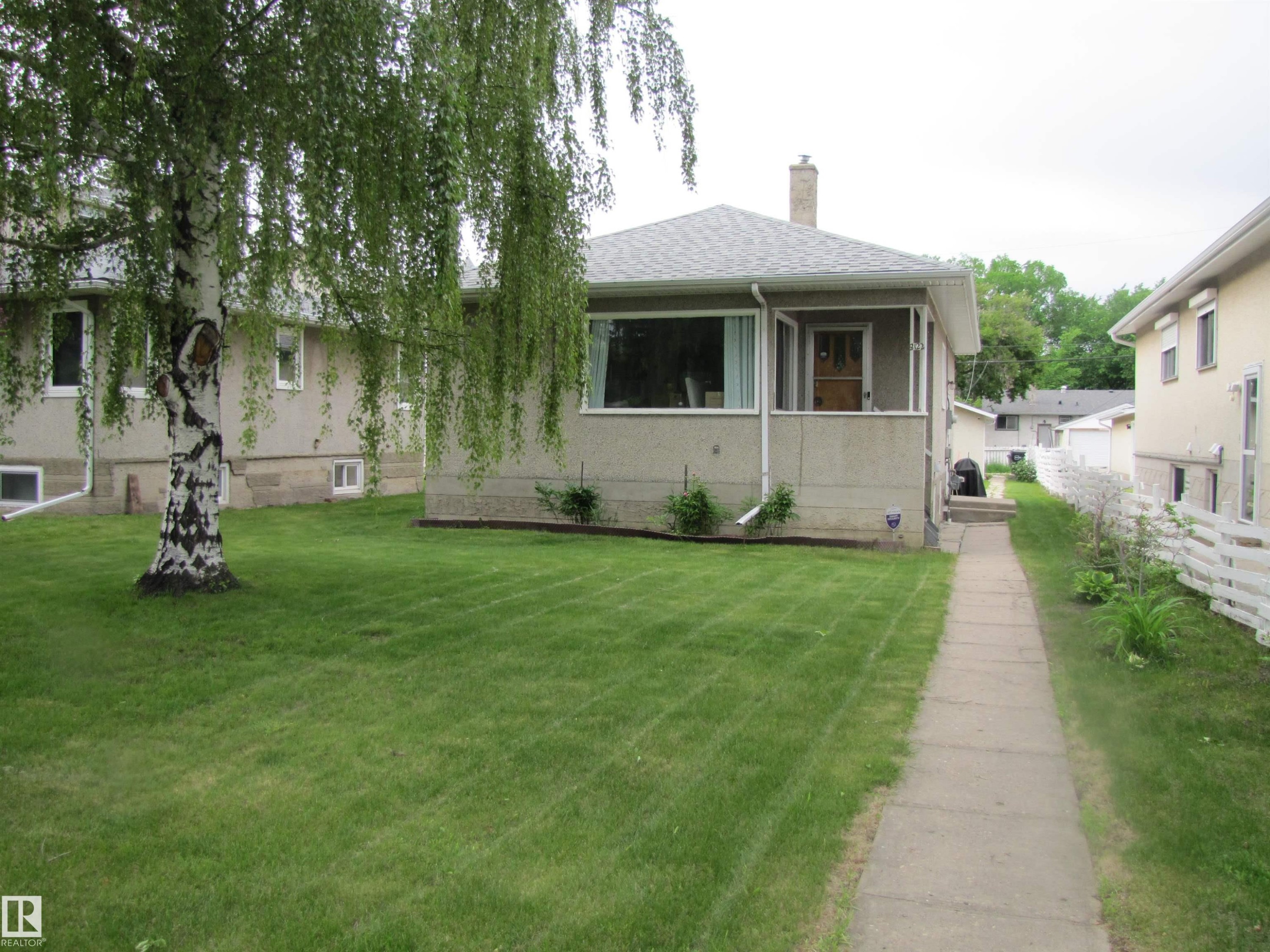 Single-story residence featuring a gray exterior finish and a prominent front window - 8122 83 Avenue, Edmonton, AB