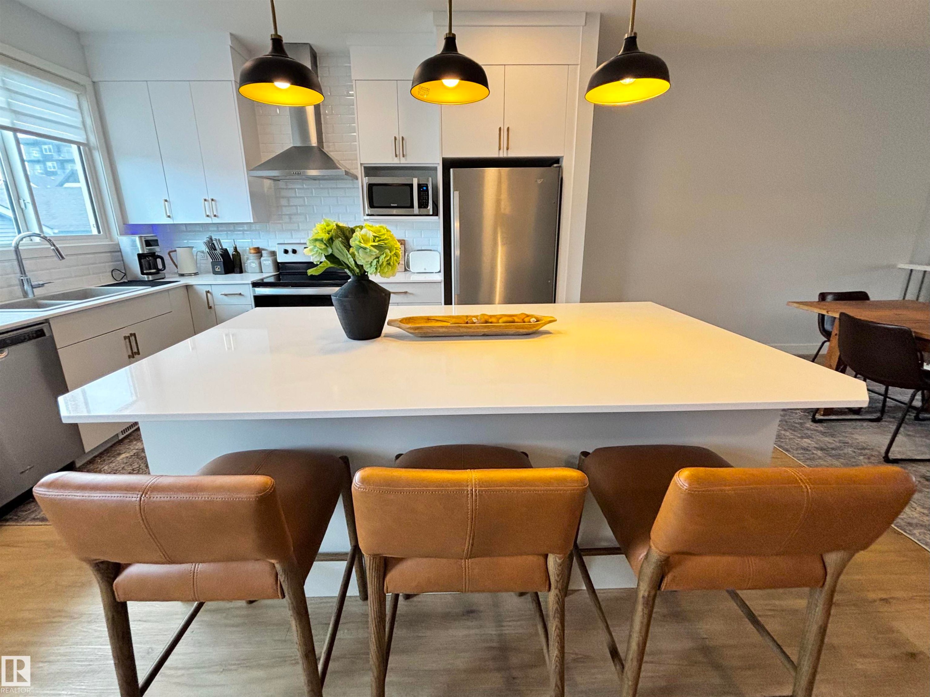 Modern kitchen island featuring a white countertop with integrated seating - 5281 Edgemont Boulevard, Edmonton, AB