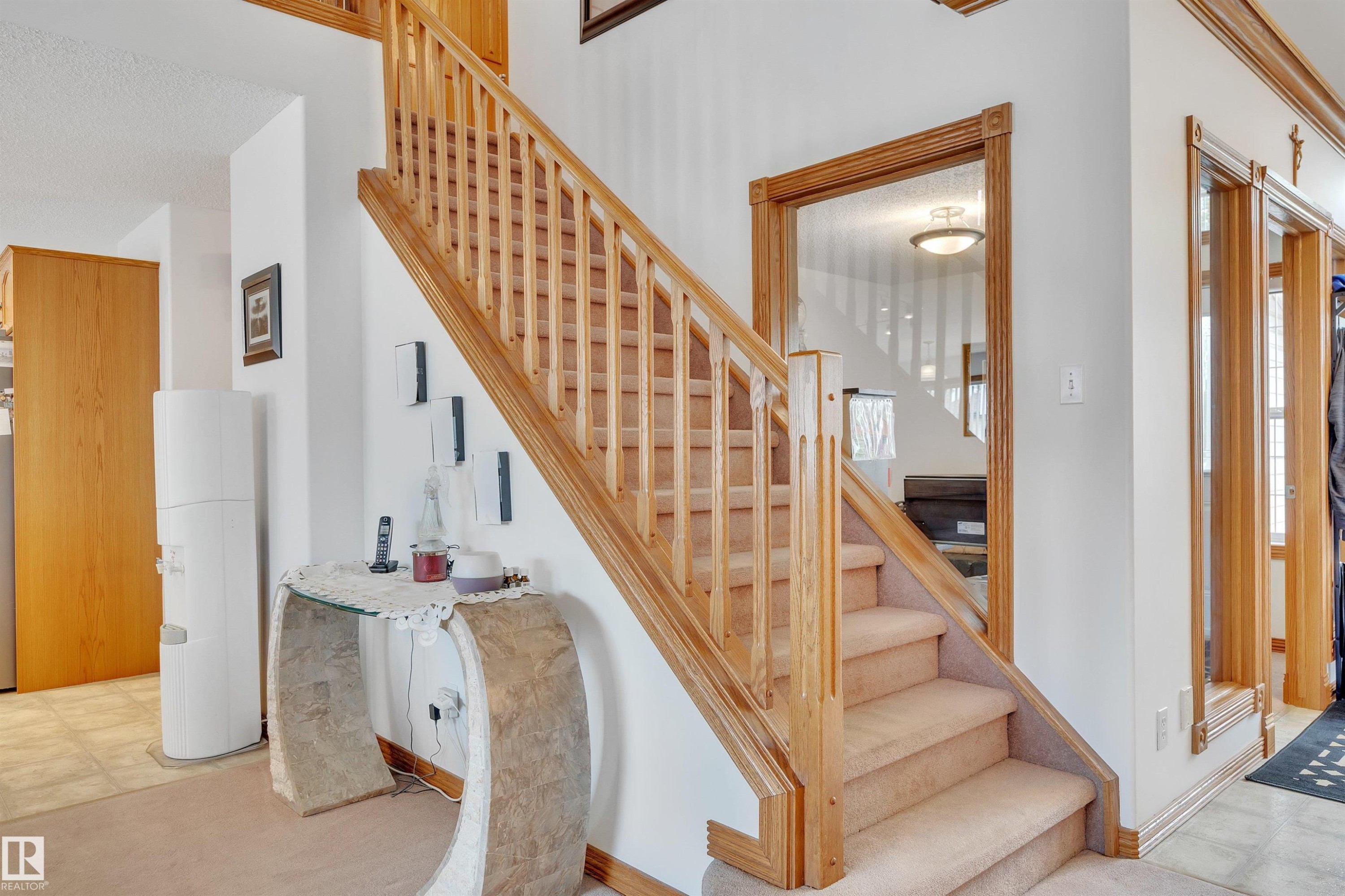 Staircase featuring wood railings and newel posts with carpeted treads - 16512 87 Street Nw, Edmonton, AB - Indoor Photo Showing Other Room