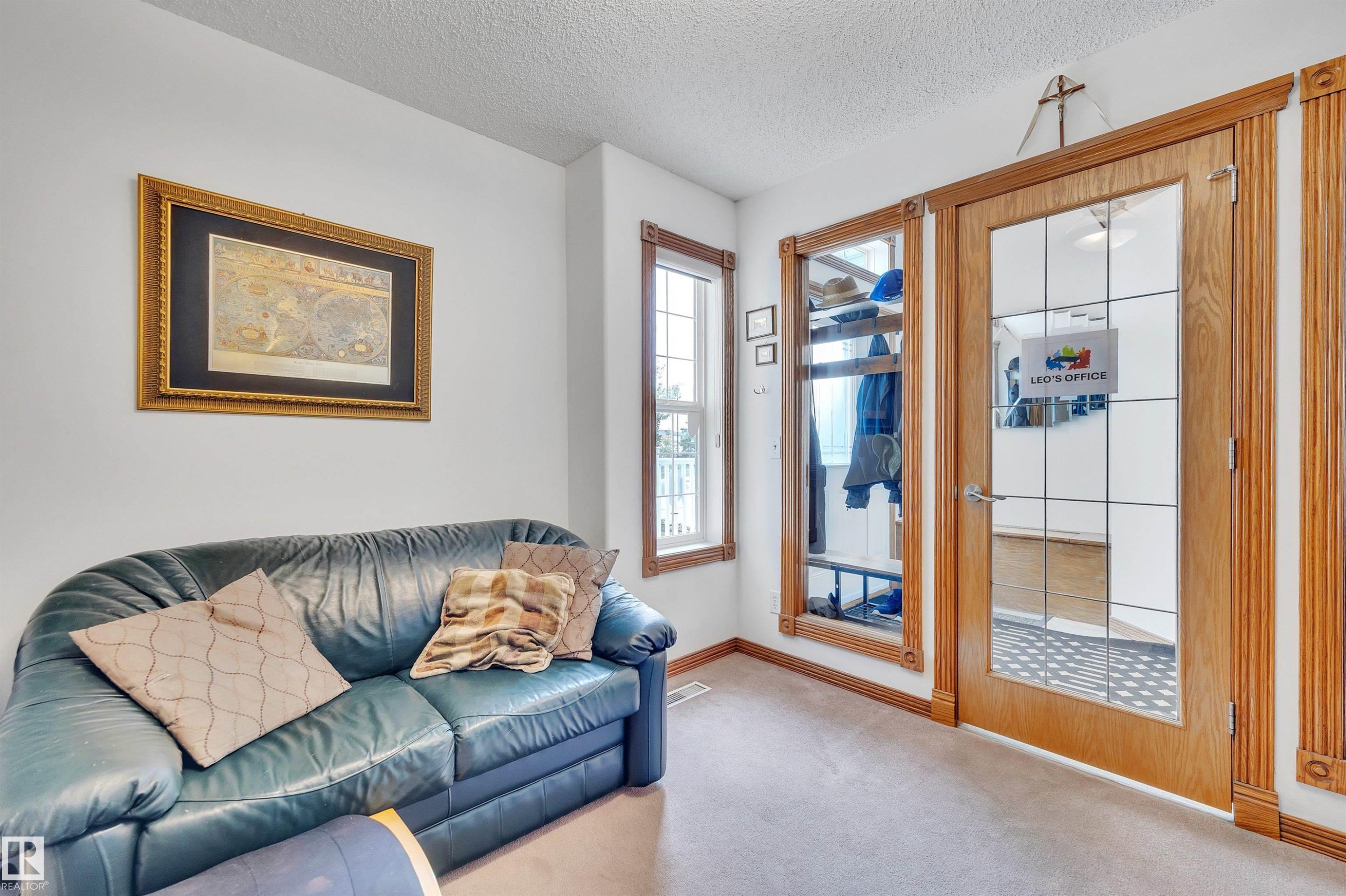 Entry area featuring a glass-paneled interior door with a wood frame, complementing window trim, and carpeted flooring - 16512 87 Street Nw, Edmonton, AB - Indoor Photo Showing Living Room