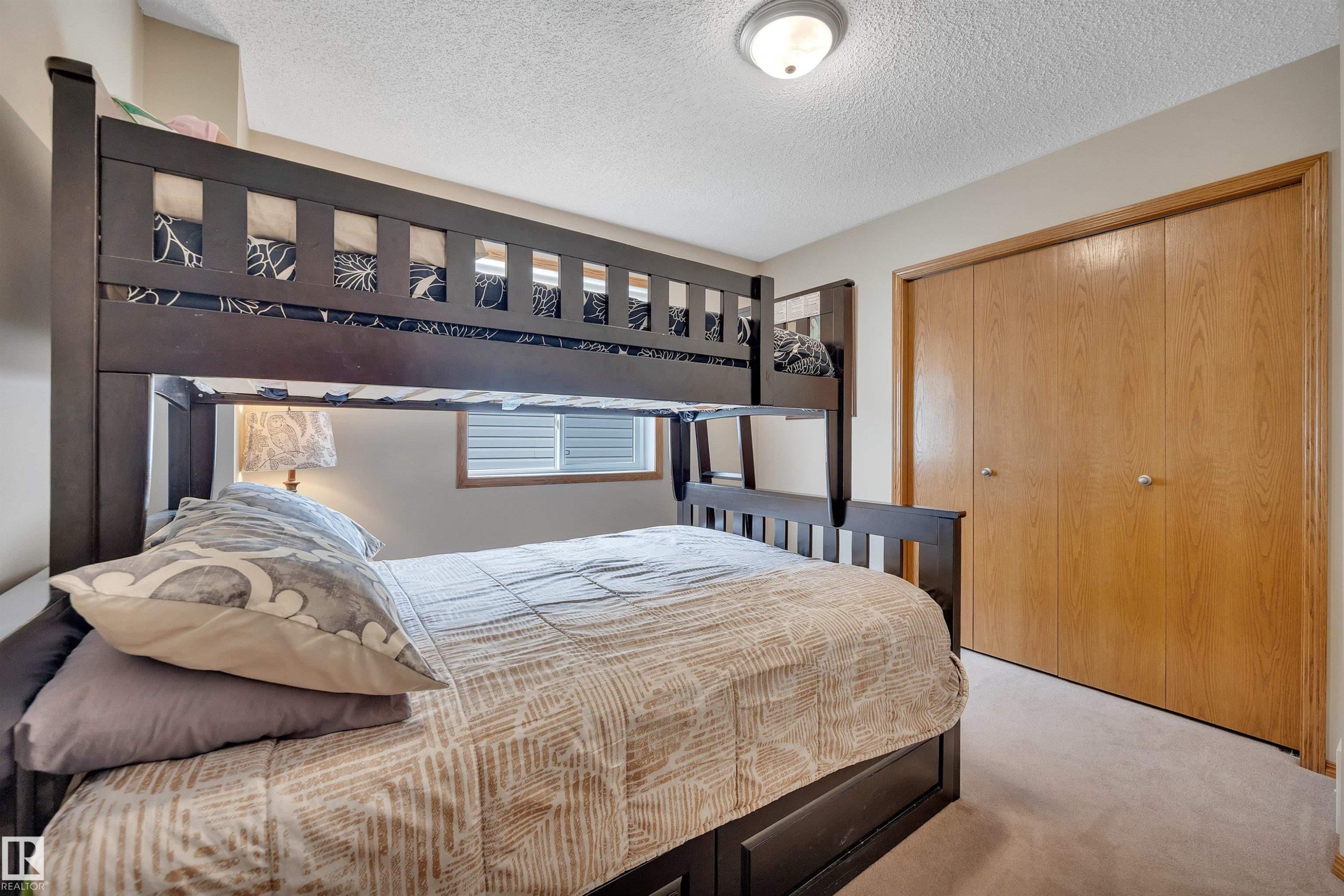 Bedroom featuring light-colored carpet flooring, a window with horizontal blinds, and a built-in closet with natural wood-finish bi-fold doors - 16512 87 Street Nw, Edmonton, AB - Indoor Photo Showing Bedroom
