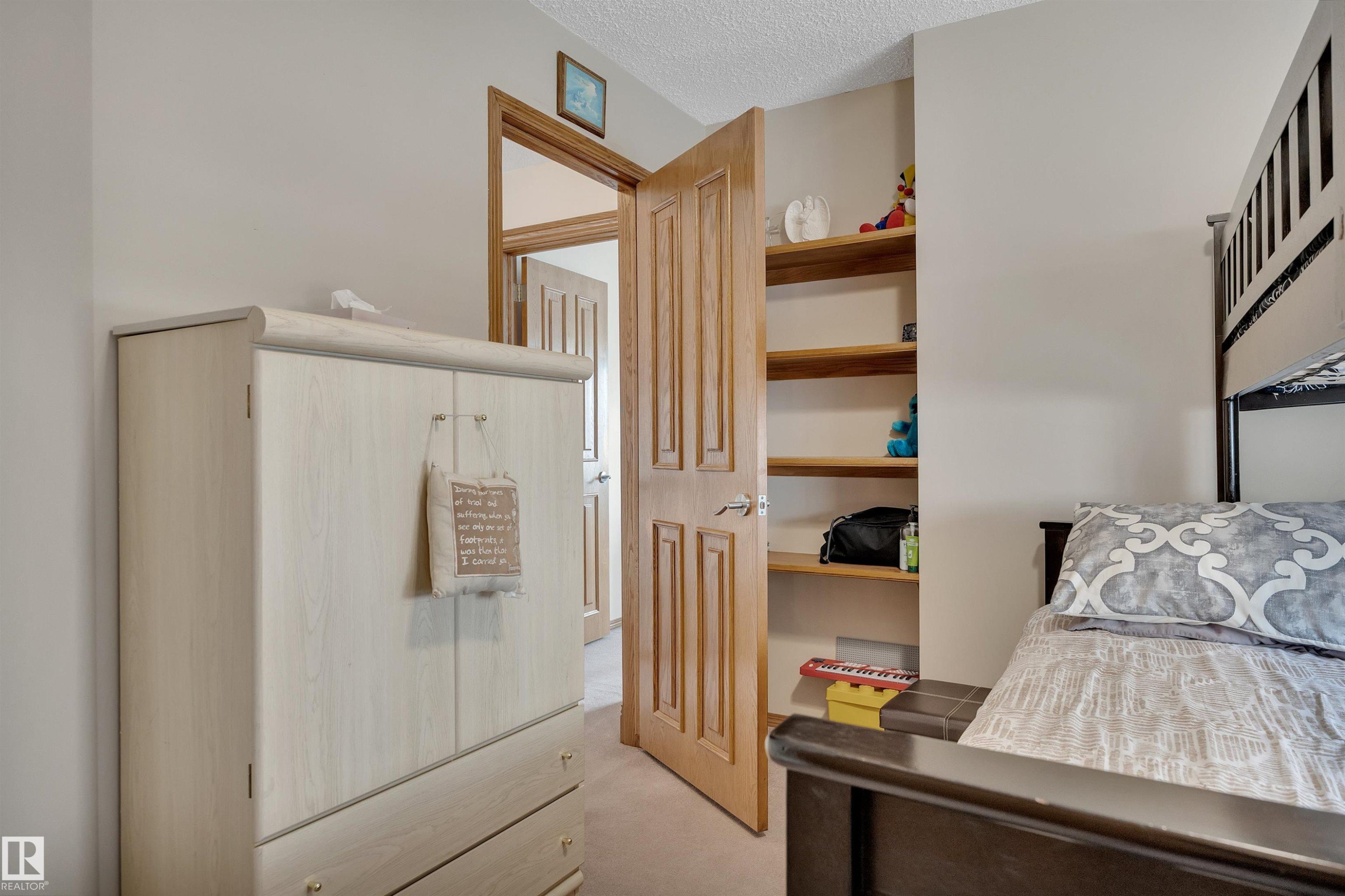 Recessed shelving with wood-finish shelves provides storage - 16512 87 Street Nw, Edmonton, AB - Indoor