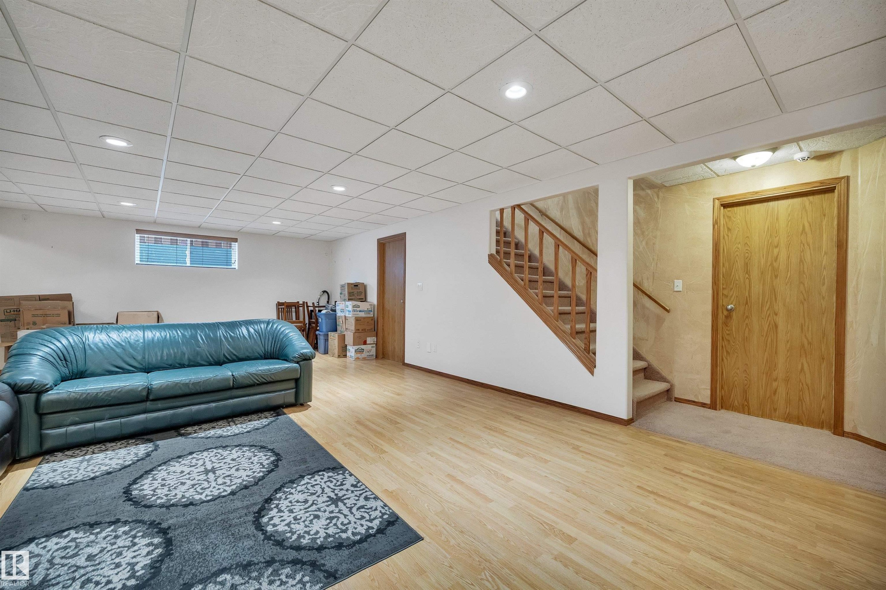 Spacious lower level featuring wood-finish flooring, recessed lighting, and a drop ceiling - 16512 87 Street Nw, Edmonton, AB - Indoor