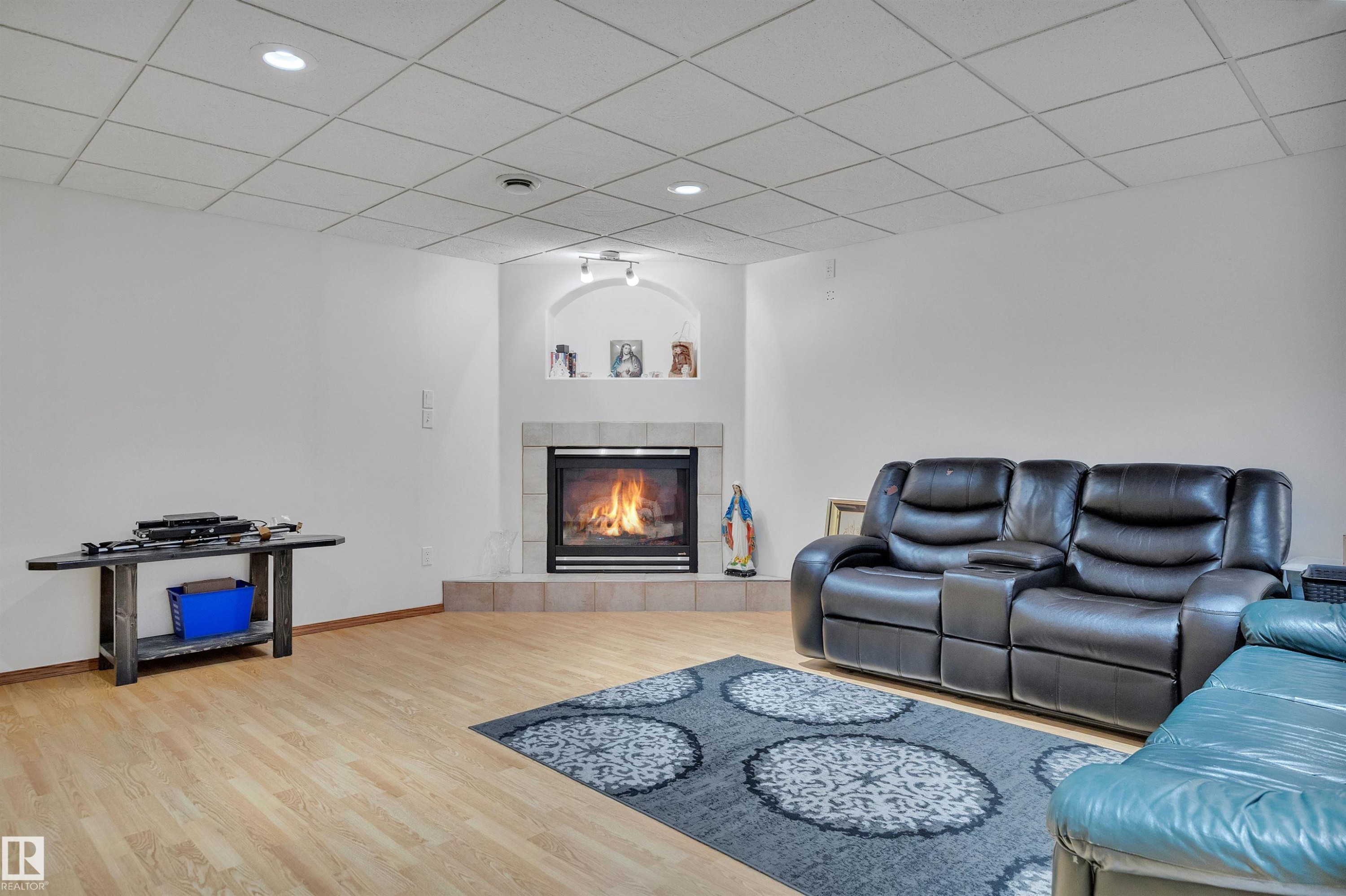 Corner fireplace with a tile surround and hearth, featuring an arched niche with recessed lighting - 16512 87 Street Nw, Edmonton, AB - Indoor Photo Showing Living Room With Fireplace