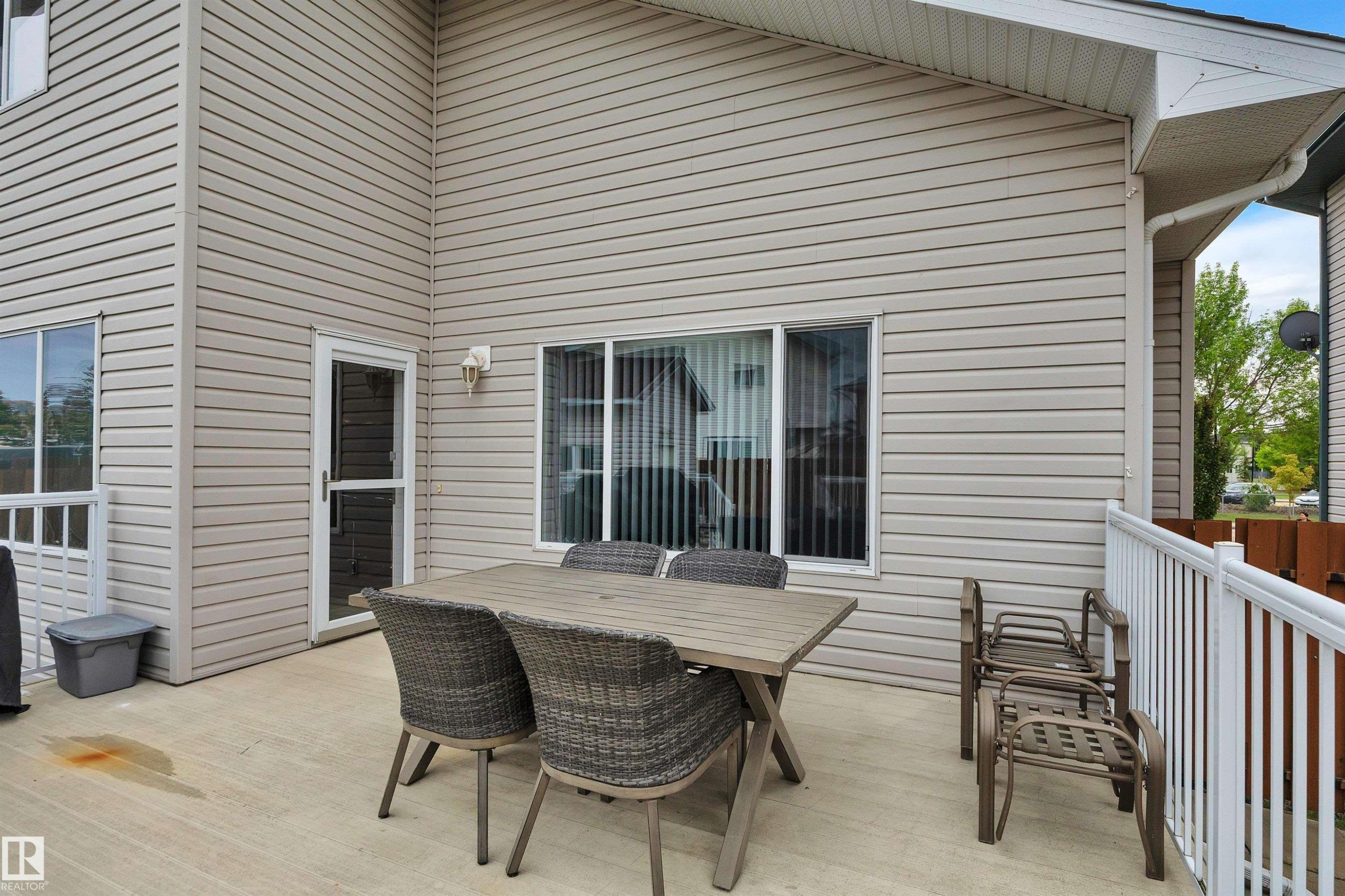Expansive outdoor deck featuring light-colored siding, a white railing, and multiple windows - 16512 87 Street Nw, Edmonton, AB - Outdoor With Exterior