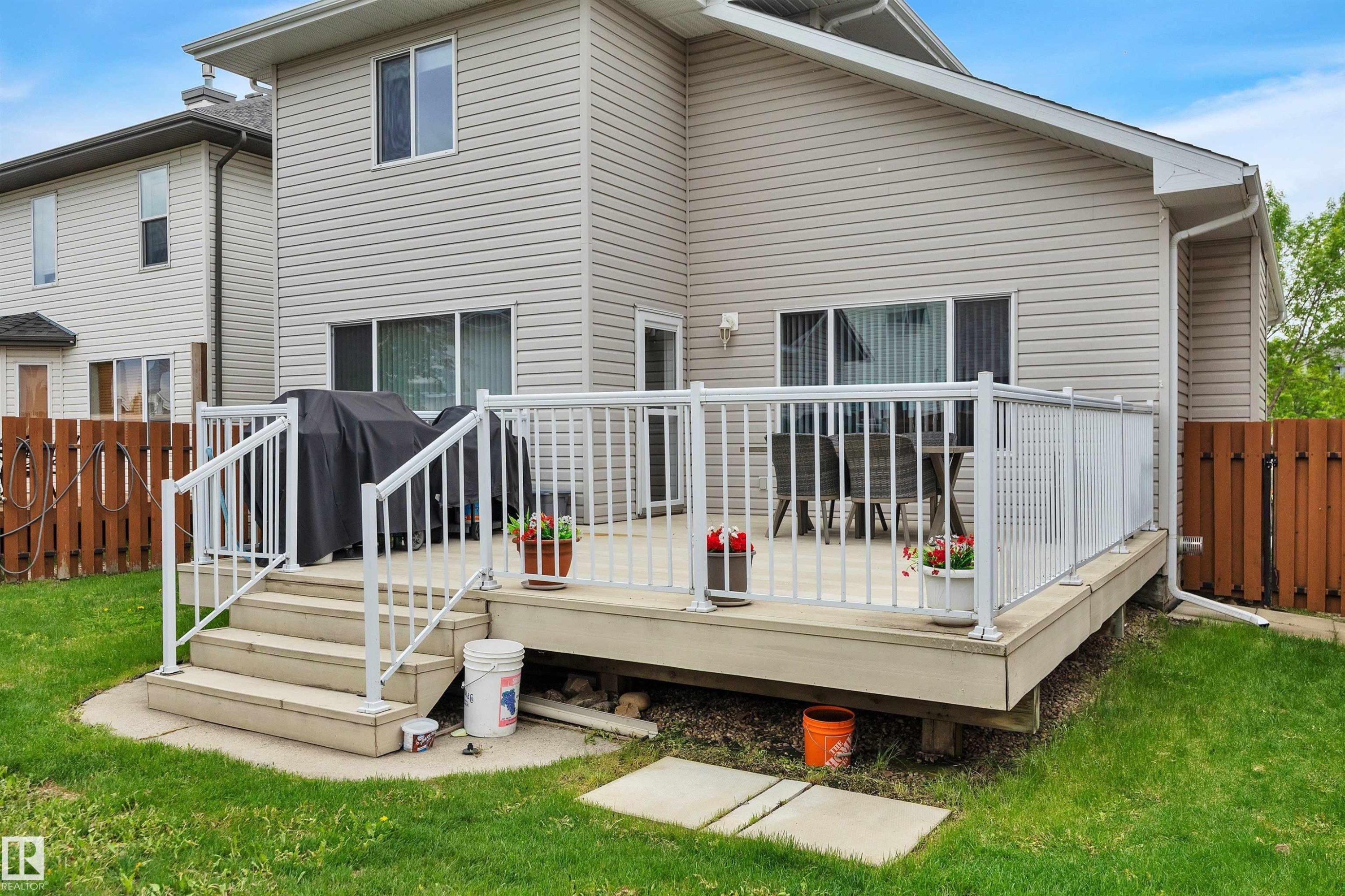 Rear exterior featuring a multi-level deck with white railings, direct backyard access, and siding - 16512 87 Street Nw, Edmonton, AB - Outdoor With Deck Patio Veranda With Exterior