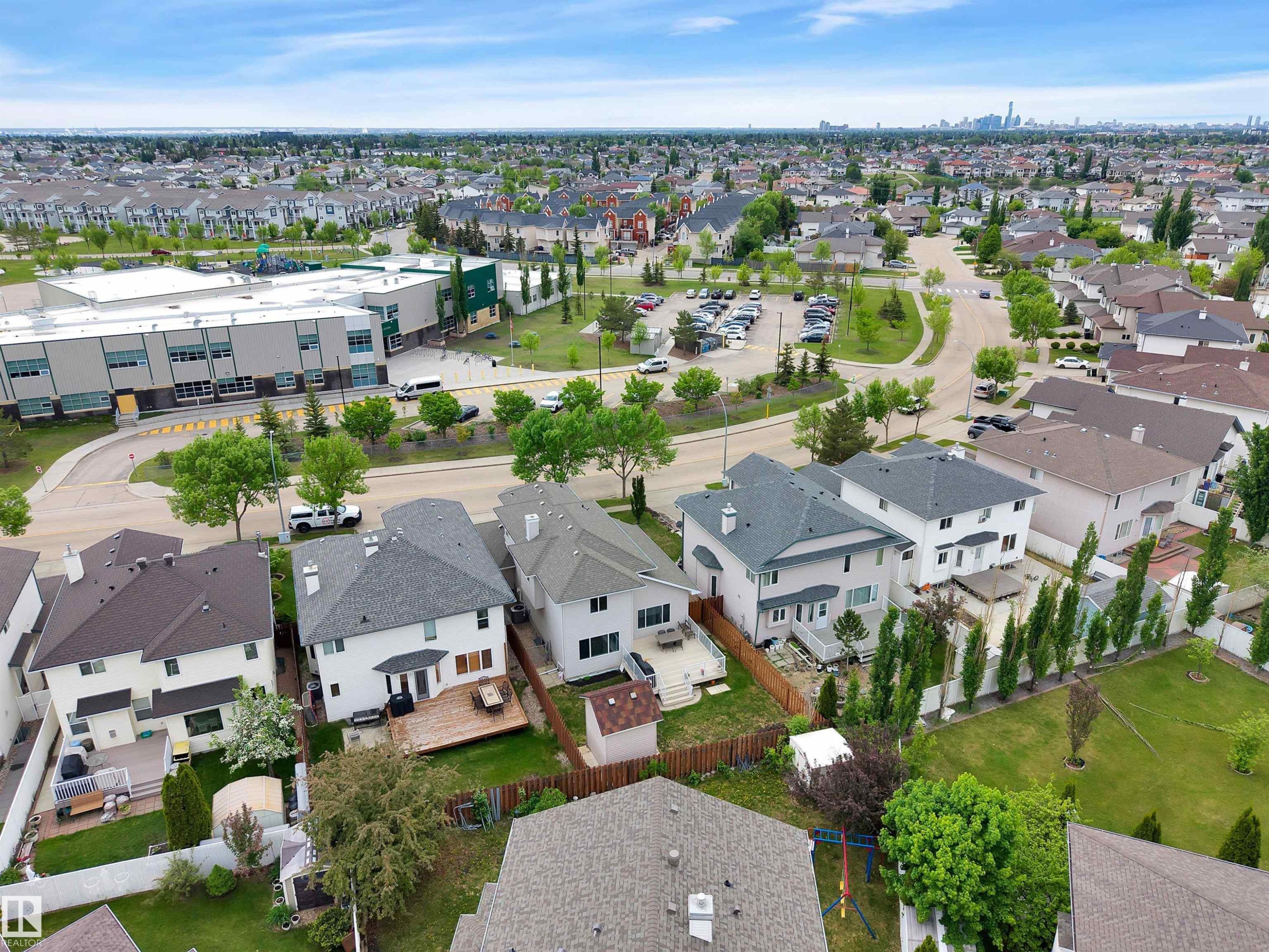 Residential neighborhood featuring detached properties with private backyards, mature landscaping, and a nearby community school with a playground - 16512 87 Street Nw, Edmonton, AB - Outdoor With View